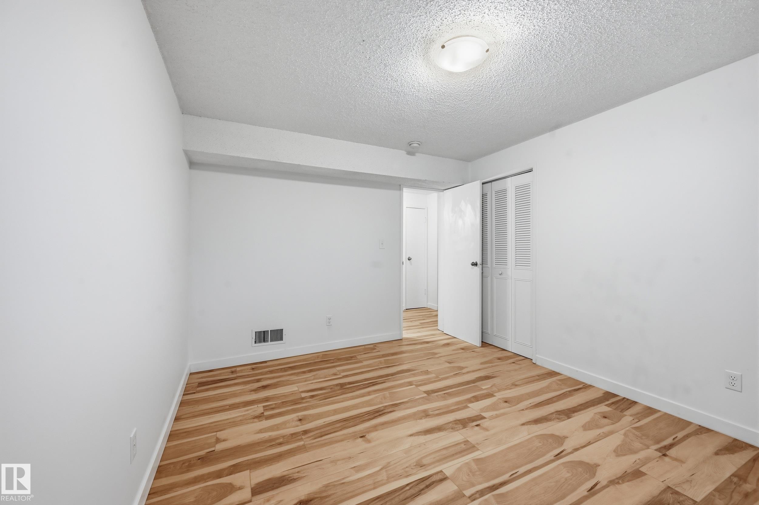 Room featuring wood-finish flooring, white walls, and a textured ceiling - 13903 87 Street, Edmonton, AB - Indoor Photo Showing Other Room
