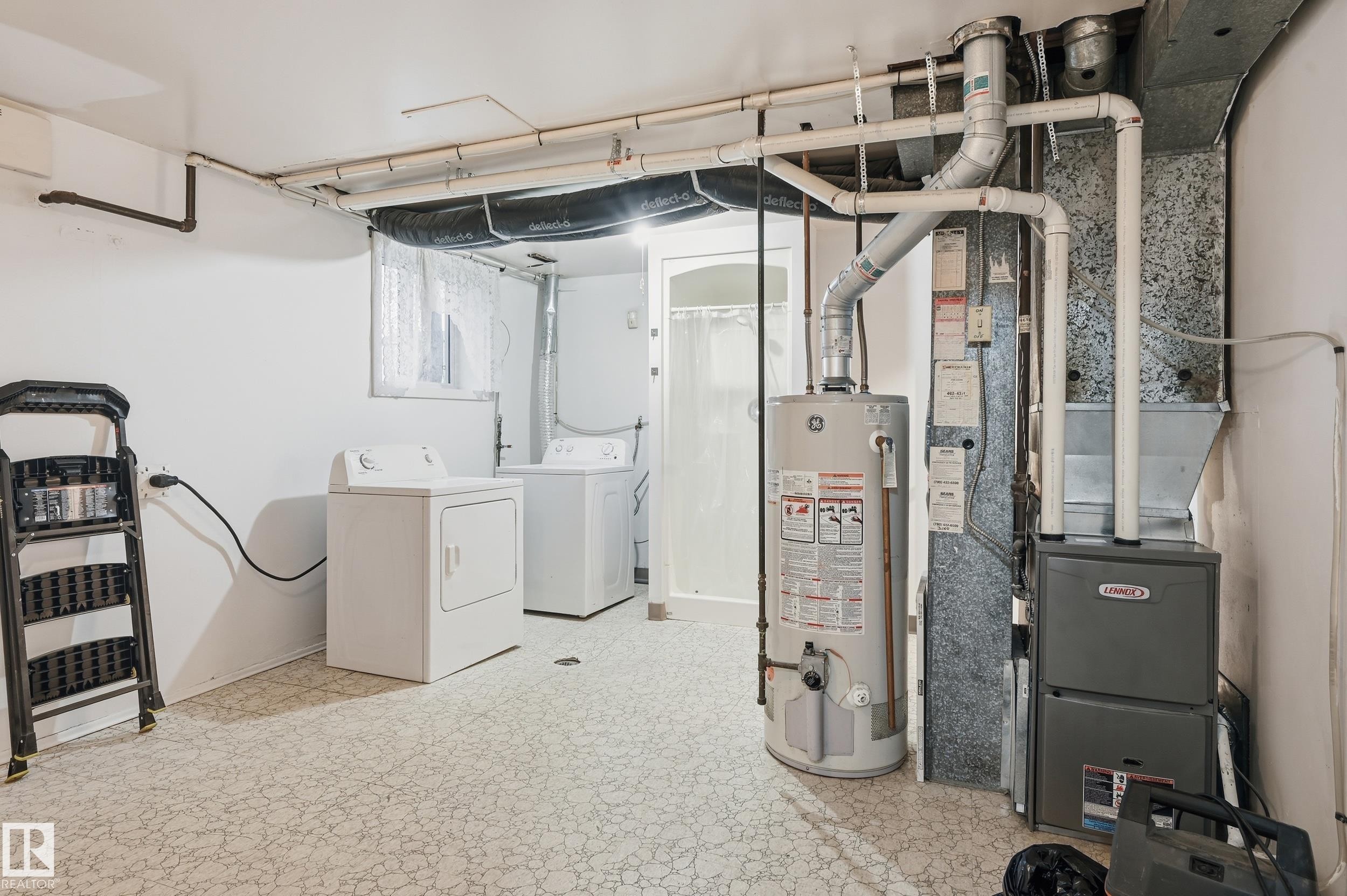 Utility area featuring a laundry space with a washer and dryer, a hot water heater, and a furnace unit - 13903 87 Street, Edmonton, AB - Indoor Photo Showing Laundry Room