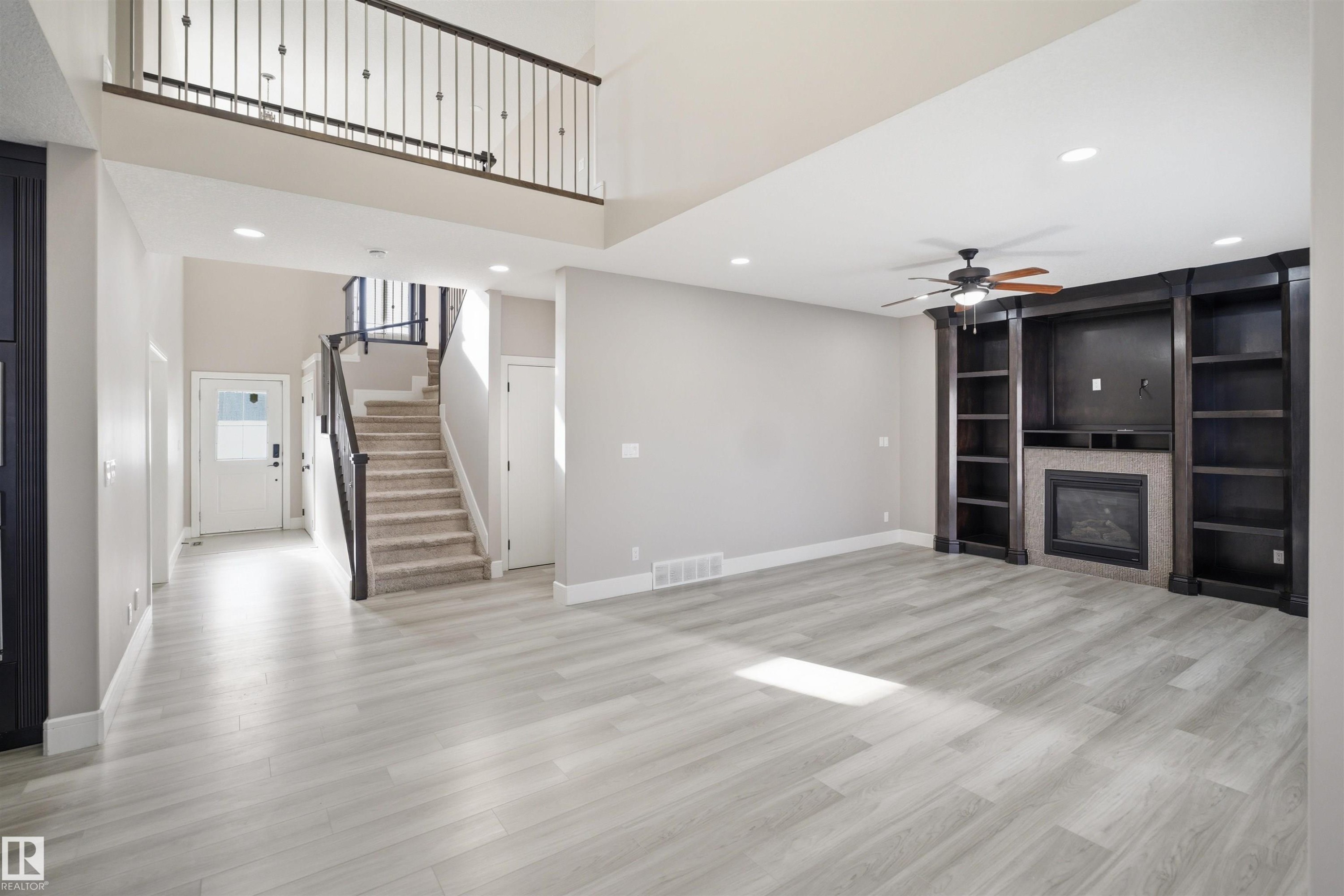 Spacious open-concept living area featuring light wood-finish flooring - 2256 Cameron Ravine Court, Edmonton, AB - Indoor With Fireplace
