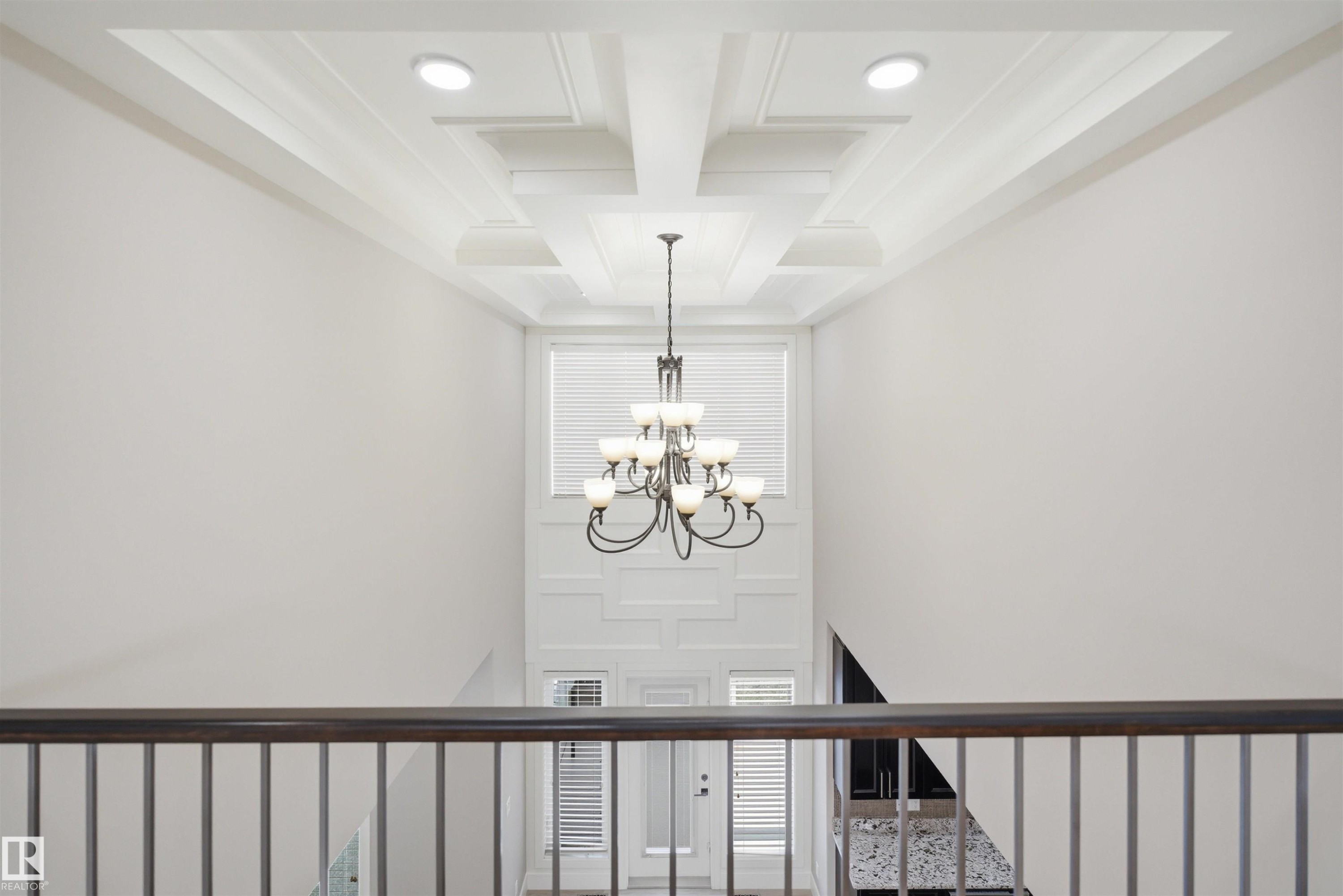 Two-story foyer featuring a coffered ceiling with recessed lighting, an ornate chandelier, and wainscoting details - 2256 Cameron Ravine Court, Edmonton, AB - Indoor Photo Showing Other Room