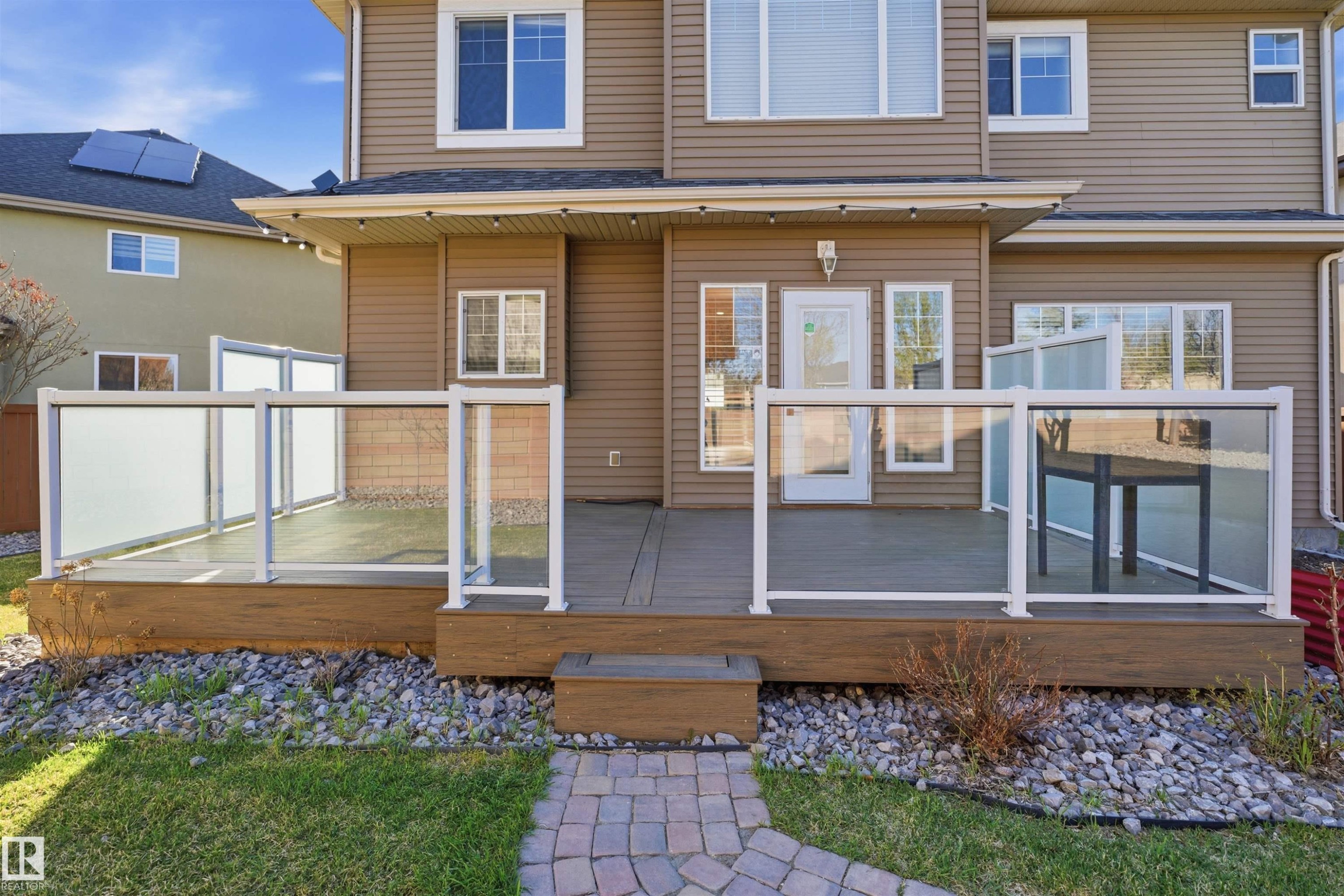 Ground-level deck featuring a glass and white aluminum railing system, with frosted privacy panels - 2256 Cameron Ravine Court, Edmonton, AB - Outdoor With Deck Patio Veranda With Exterior