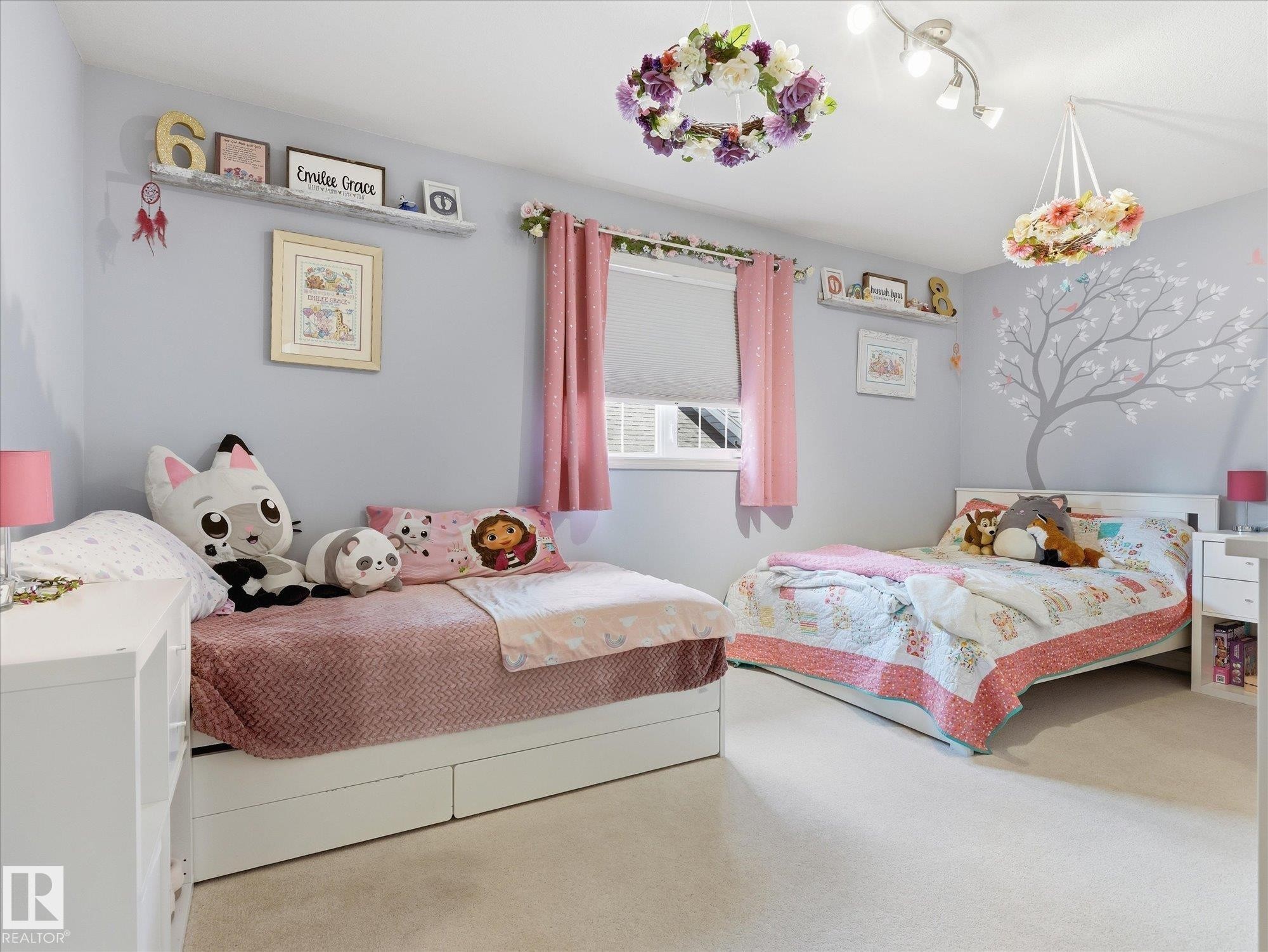 Light gray painted walls with a decorative tree decal, plush carpeting, and two windows with roller shades - 1340 Oakland Crescent, Devon, AB - Indoor Photo Showing Bedroom