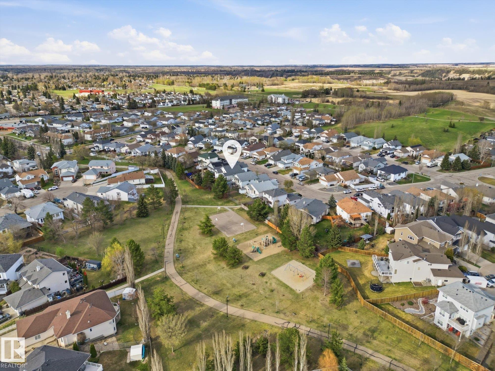 Residential neighborhood featuring varied architectural styles and an expansive green space with recreational amenities - 1340 Oakland Crescent, Devon, AB - Outdoor With View