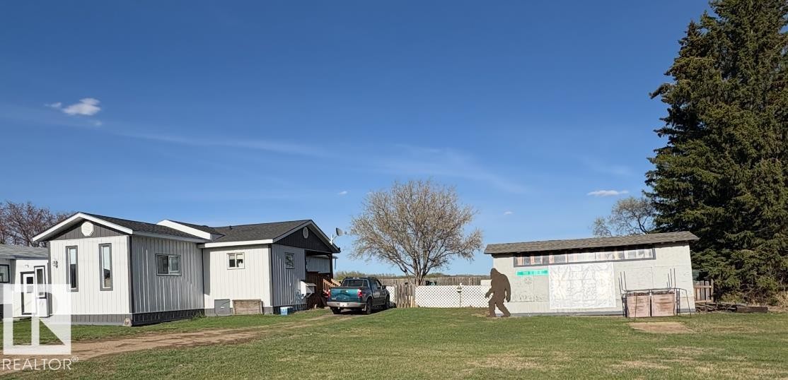 White vertical siding exterior with dark trim and a dark shingle roof. Two lots. - 115 2Nd Street E, Derwent, AB - Outdoor