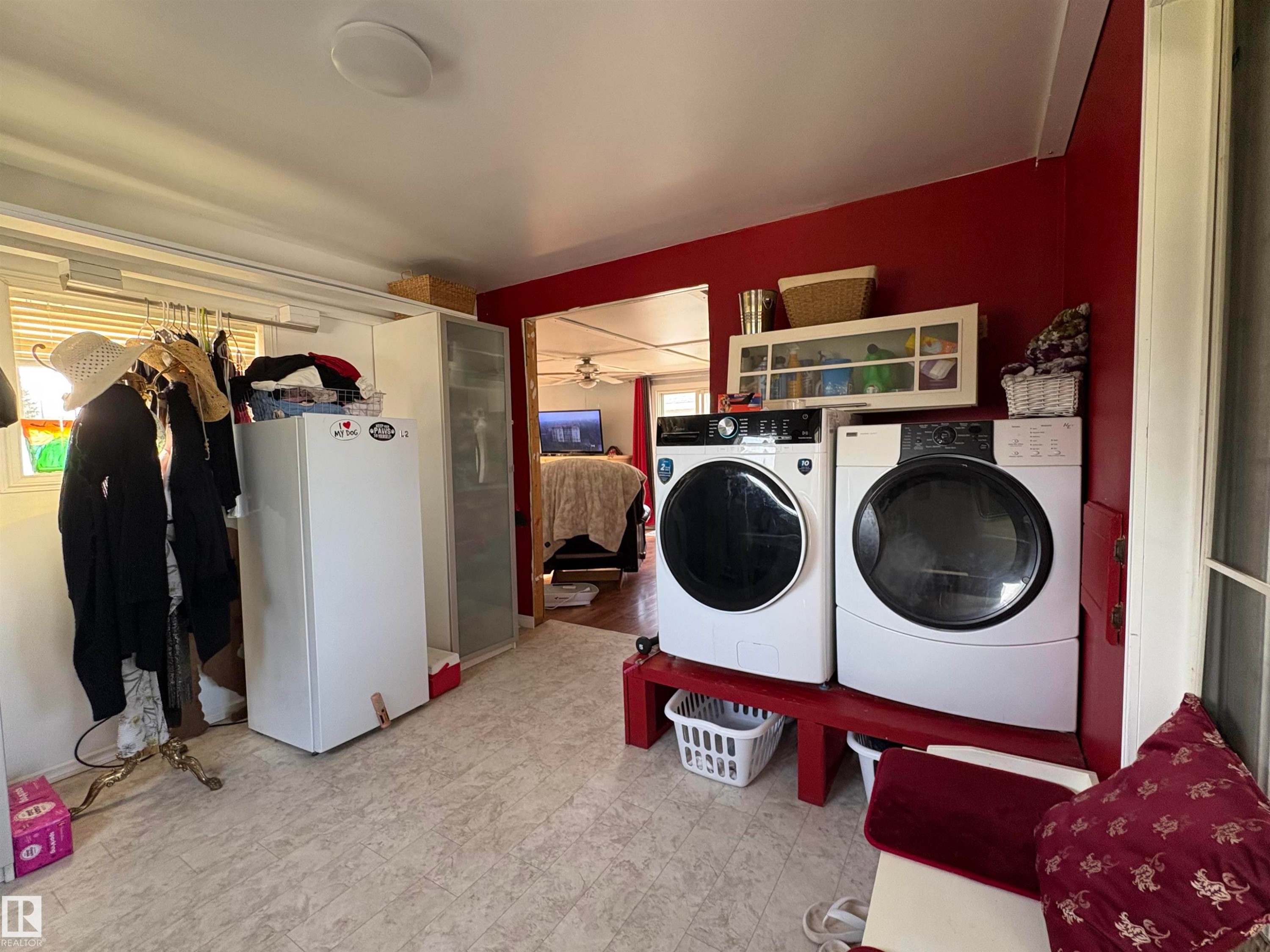 laundry area featuring a washer and dryer, patterned flooring, and a window for natural light. Located in front entry. - 115 2Nd Street E, Derwent, AB - Indoor Photo Showing Laundry Room
