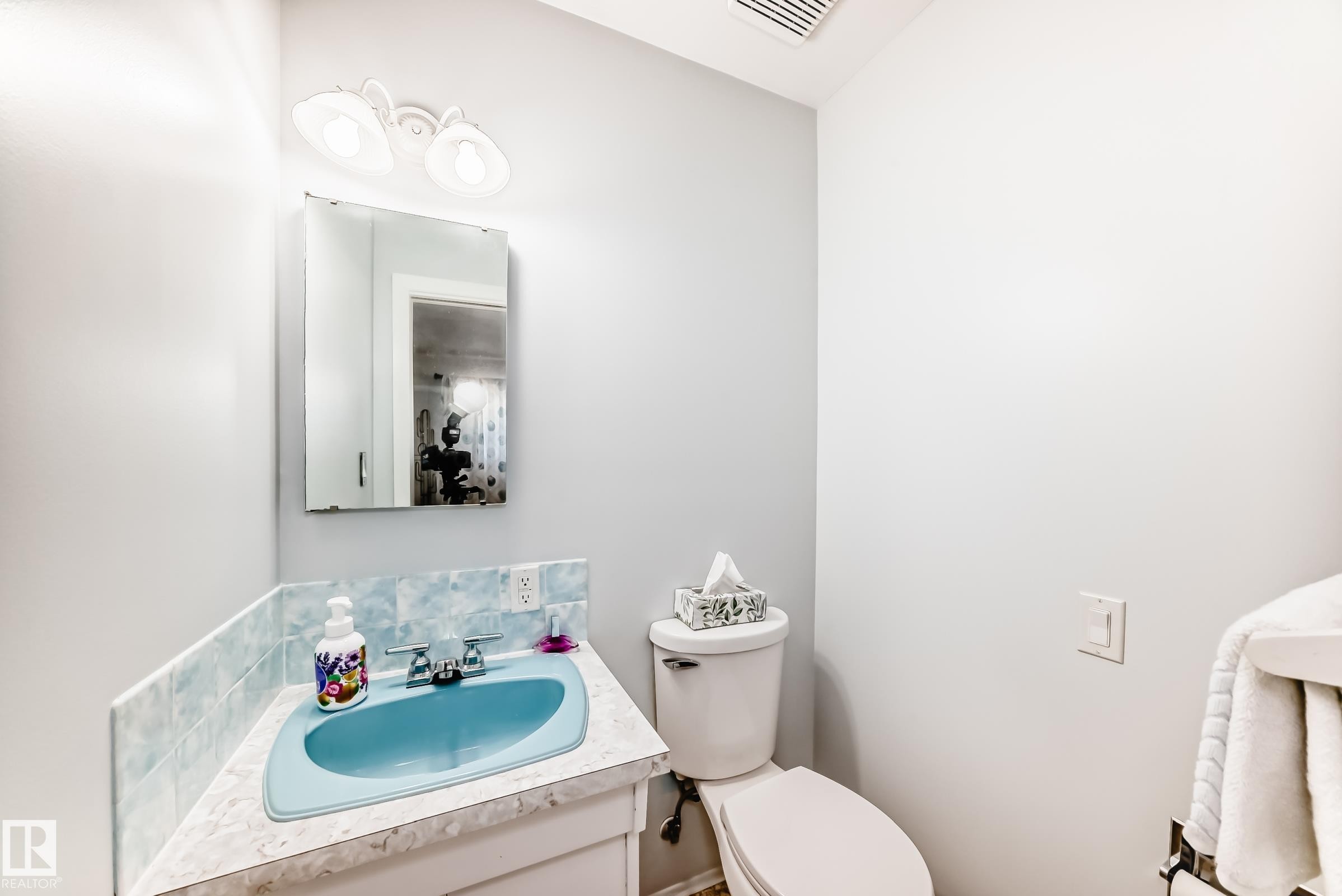 Bathroom featuring a blue porcelain sink, a vanity with a laminate countertop, and a wall-mounted medicine cabinet - 3611 108 Street, Edmonton, AB - Indoor Photo Showing Bathroom