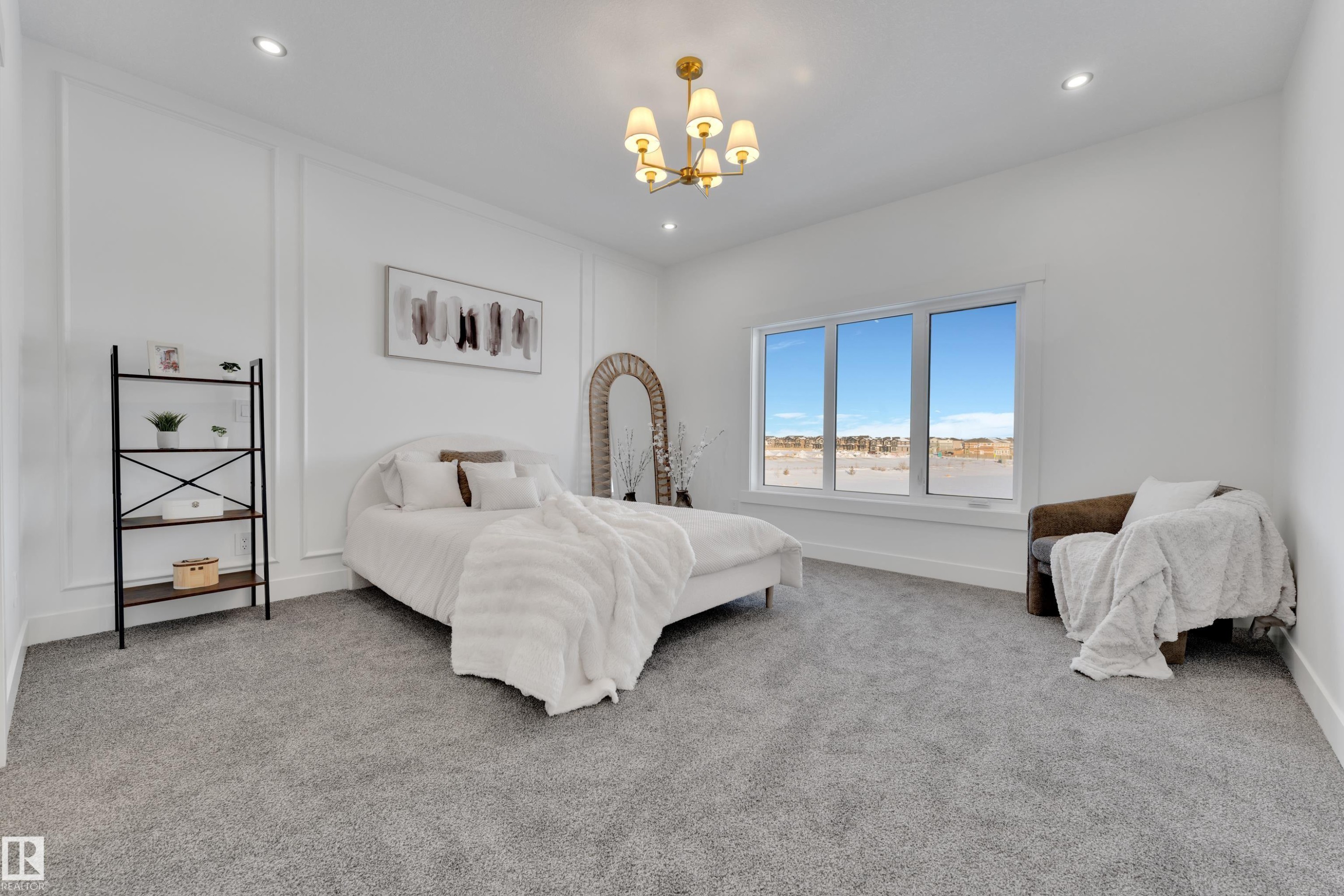 Spacious room featuring light gray carpeting, recessed ceiling lighting, a gold-toned chandelier, large window, and decorative wall molding - 382 Linden Loop, Leduc, AB - Indoor Photo Showing Bedroom