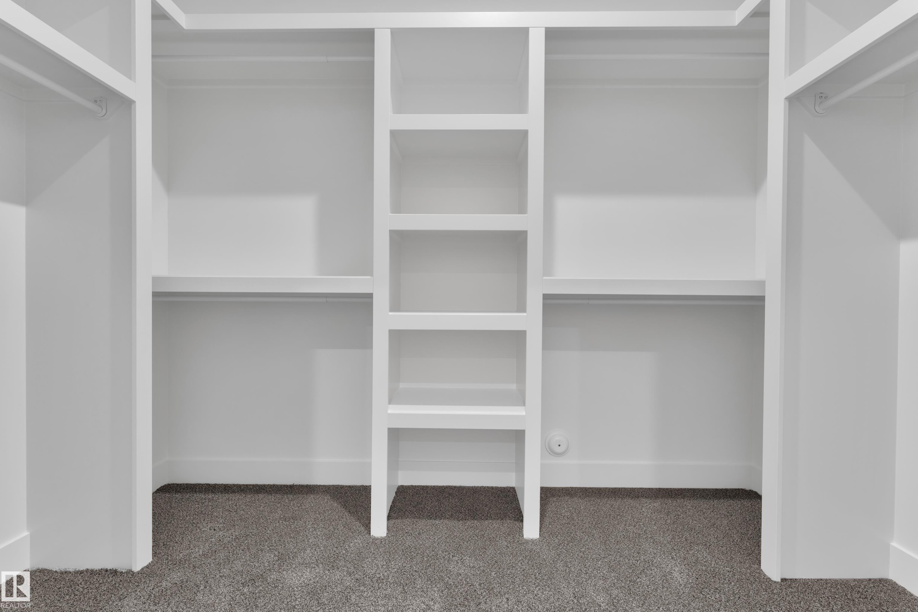 Built-in white storage system featuring multiple shelves and hanging rods - 382 Linden Loop, Leduc, AB - Indoor With Storage