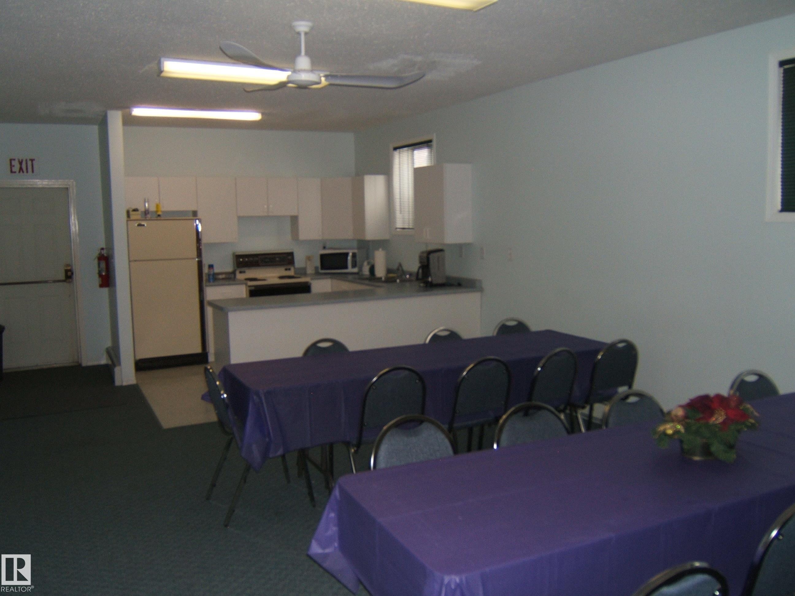 Kitchenette area featuring white cabinetry, light-toned countertops, and a service bar - 4707 50 Street, Two Hills, AB - Indoor