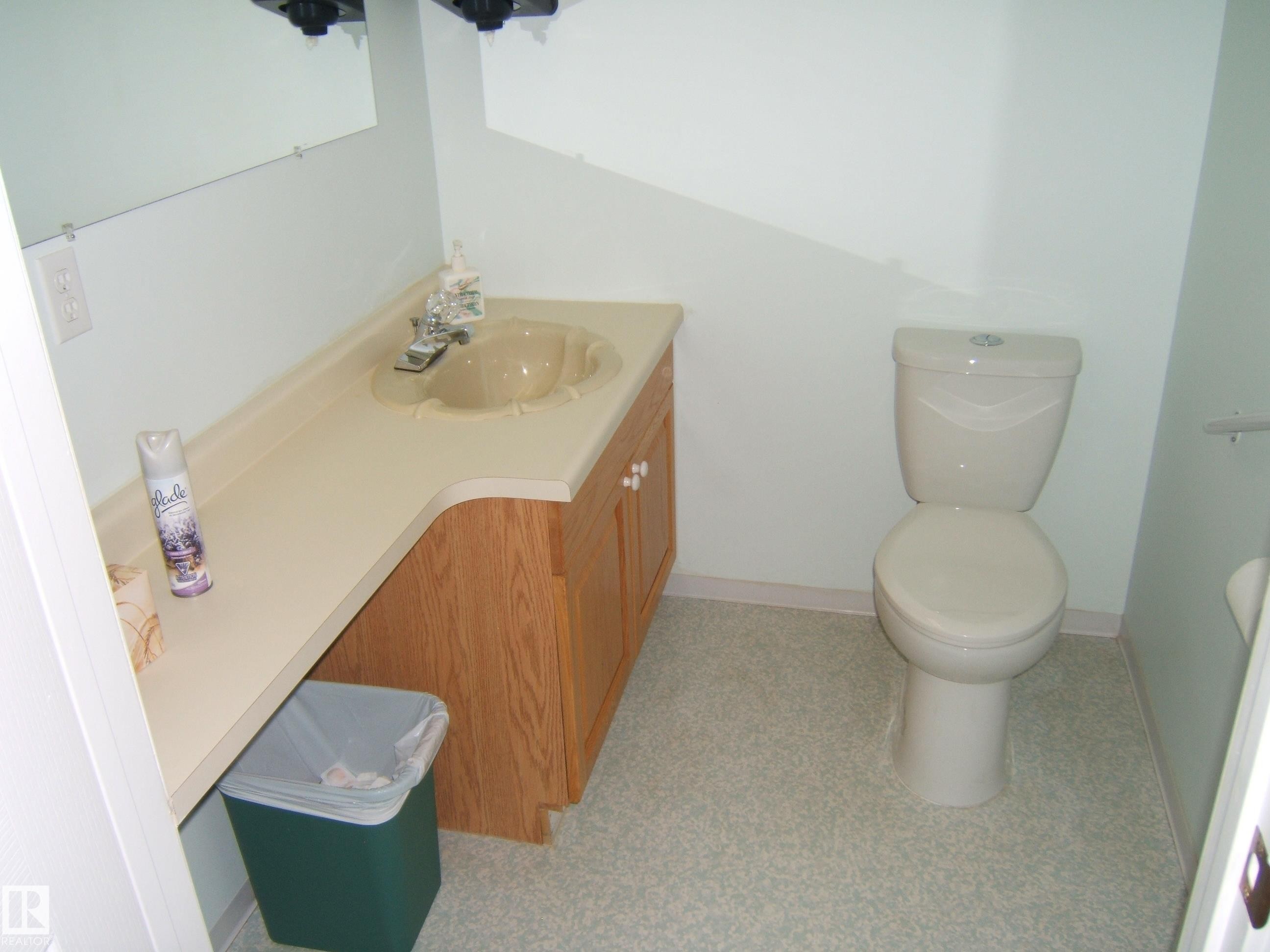 Bathroom featuring a light-colored vanity with an integrated sink and wood-finish cabinetry - 4707 50 Street, Two Hills, AB - Indoor Photo Showing Bathroom