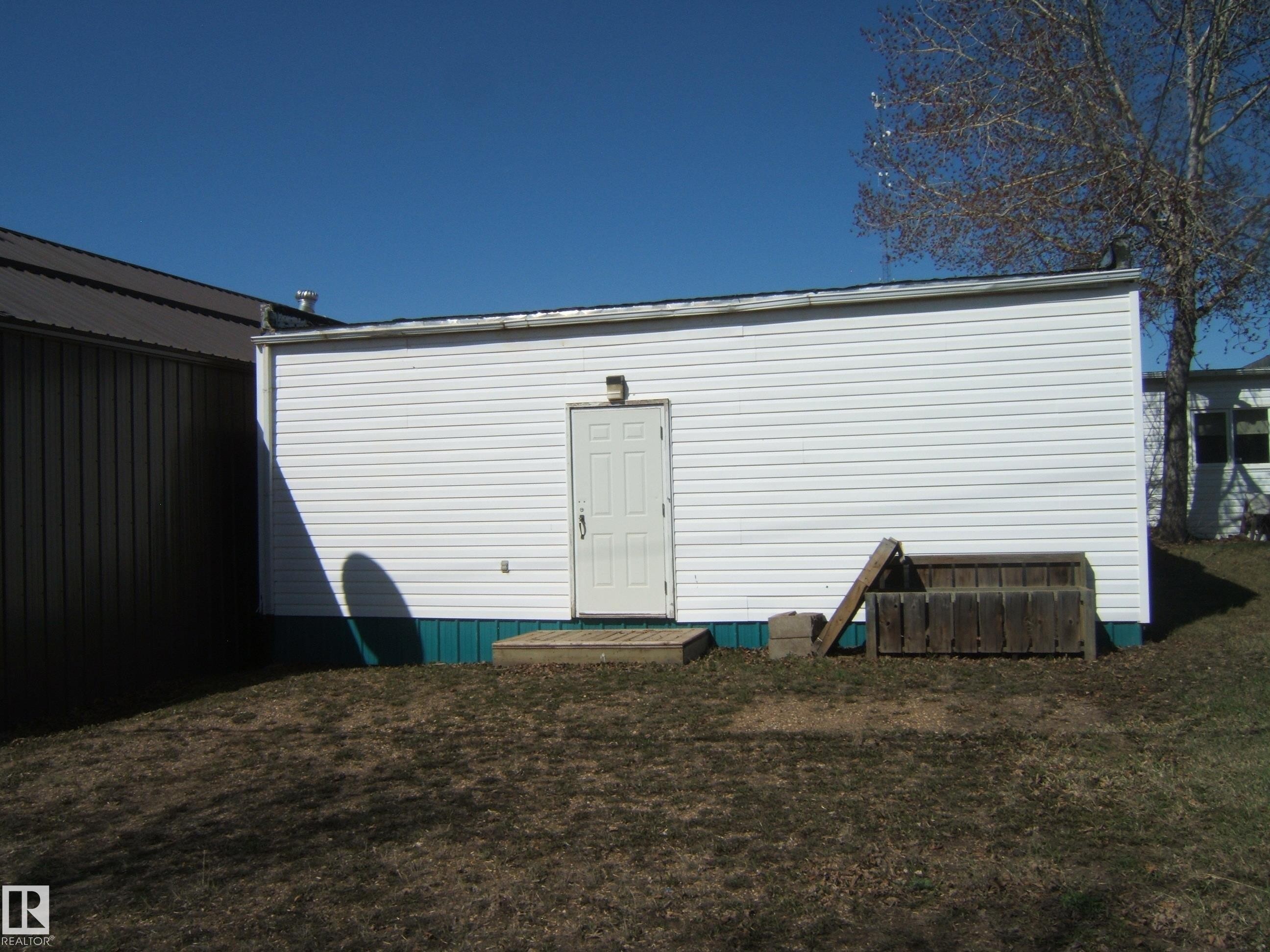 White vinyl-sided exterior building with a flat roof - 4707 50 Street, Two Hills, AB - Outdoor