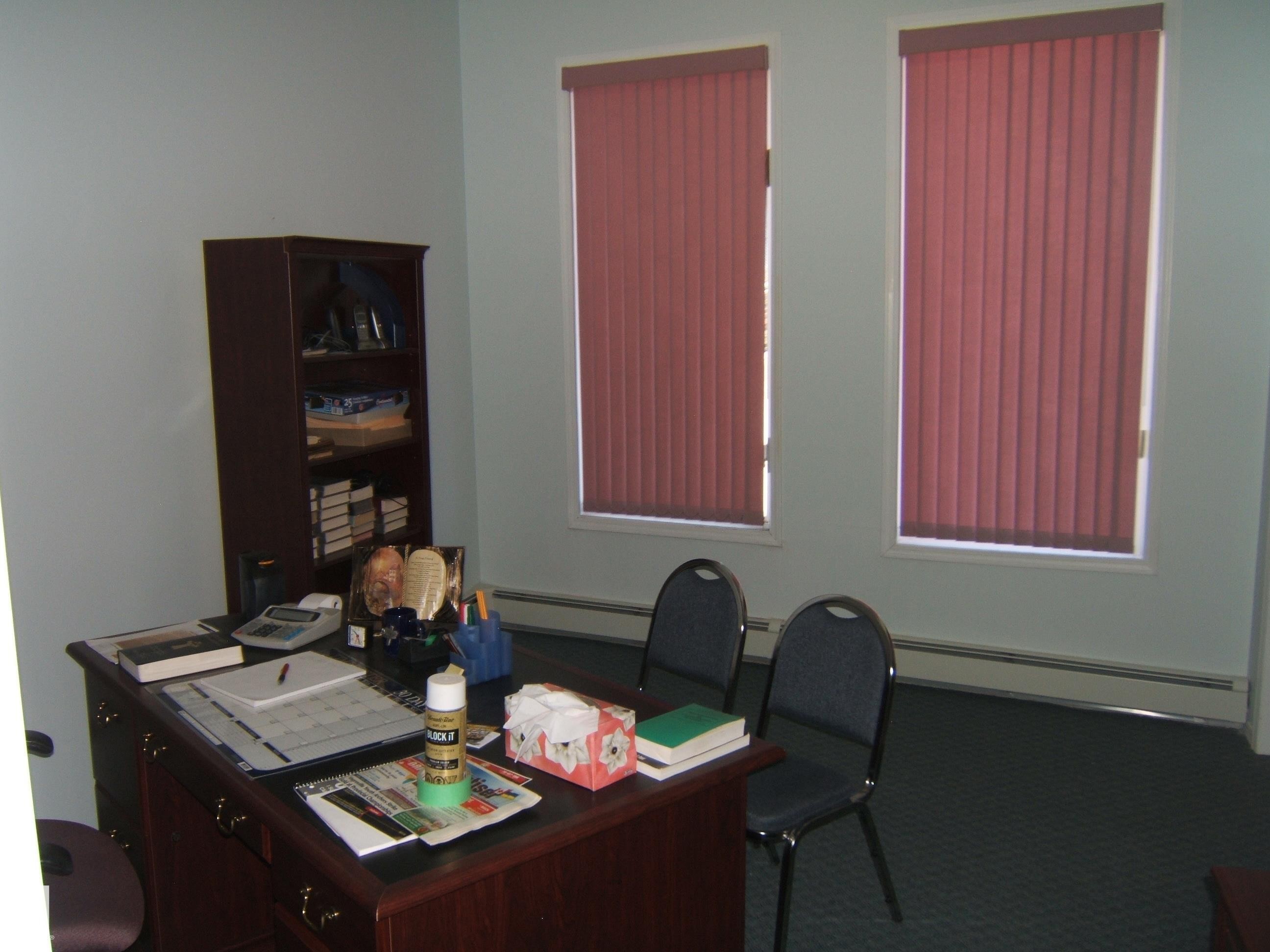 Room featuring two windows with vertical blinds, light-colored walls, and dark carpeting - 4707 50 Street, Two Hills, AB - Indoor Photo Showing Office