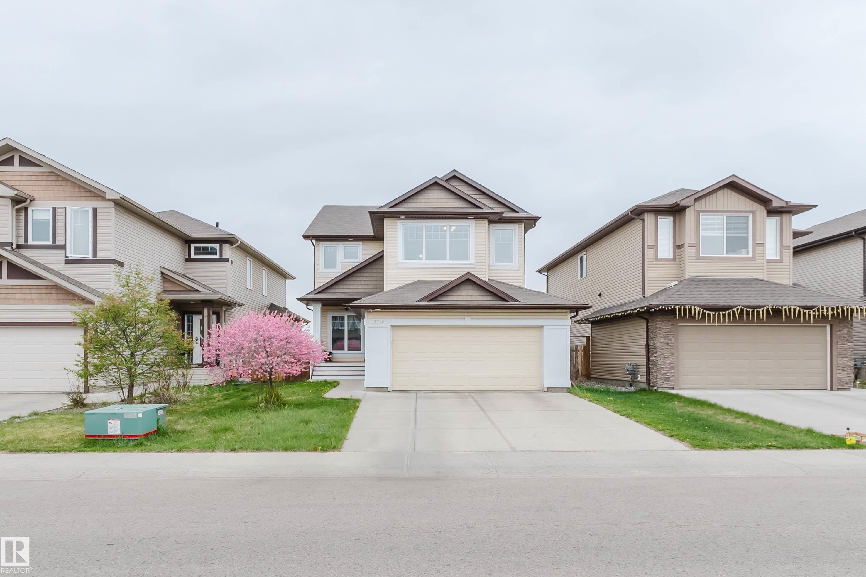 Two-story residence featuring light-colored siding with contrasting brown trim, an attached two-car garage, and a concrete driveway - 17718 5A Avenue, Edmonton, AB - Outdoor With Facade
