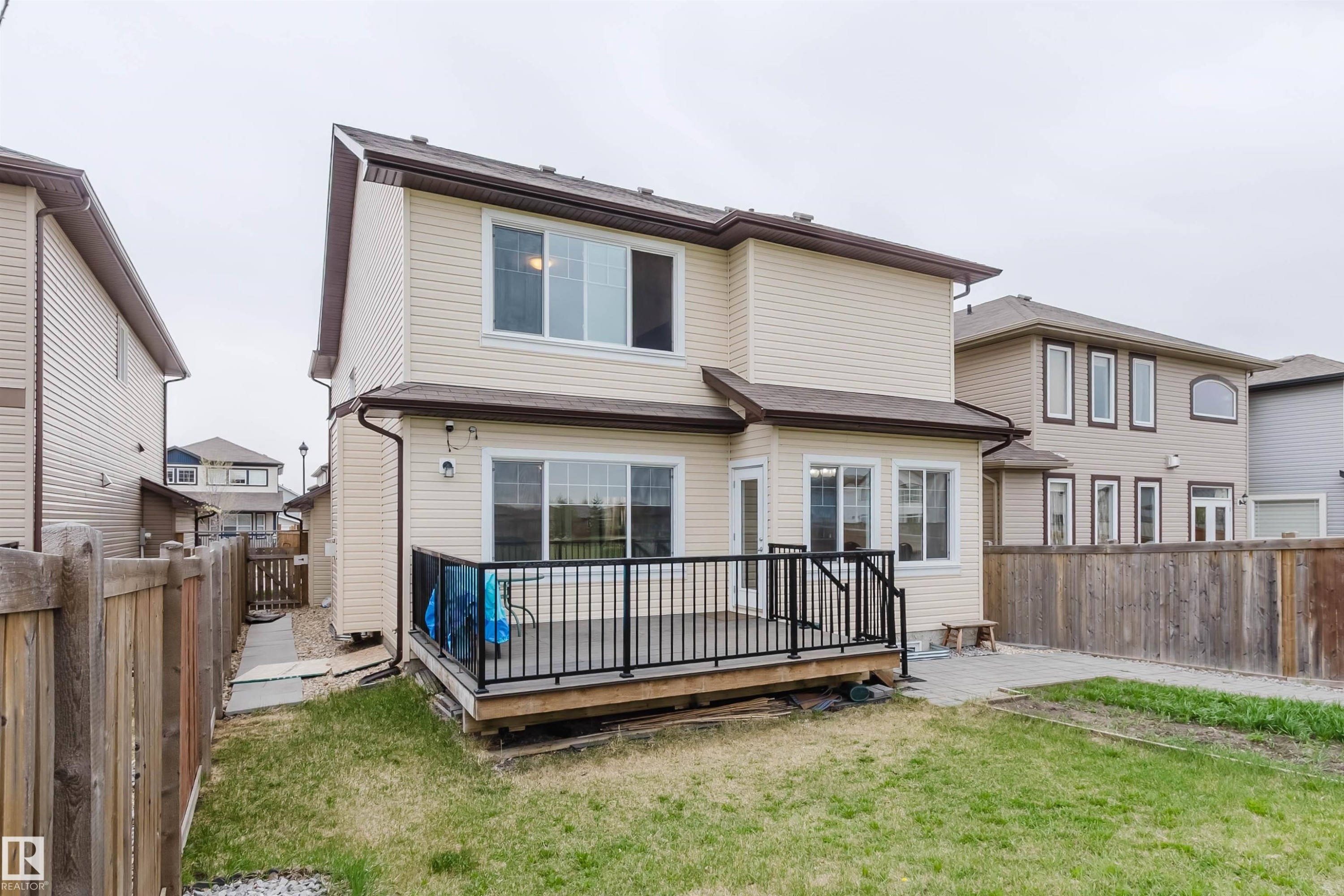 Rear exterior showcasing a two-story residence with light-colored siding - 17718 5A Avenue, Edmonton, AB - Outdoor With Exterior