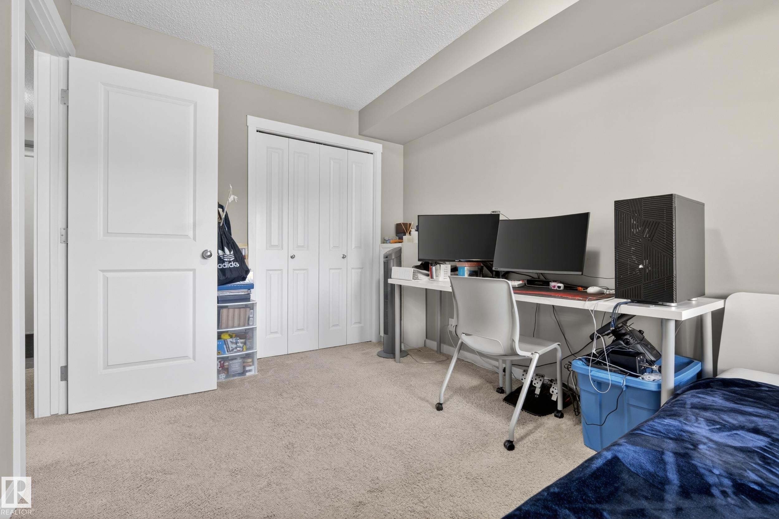 Neutral-toned walls complement the textured ceiling and light-colored carpet - 314 3211 James Mowatt Trail Sw, Edmonton, AB - Indoor Photo Showing Office