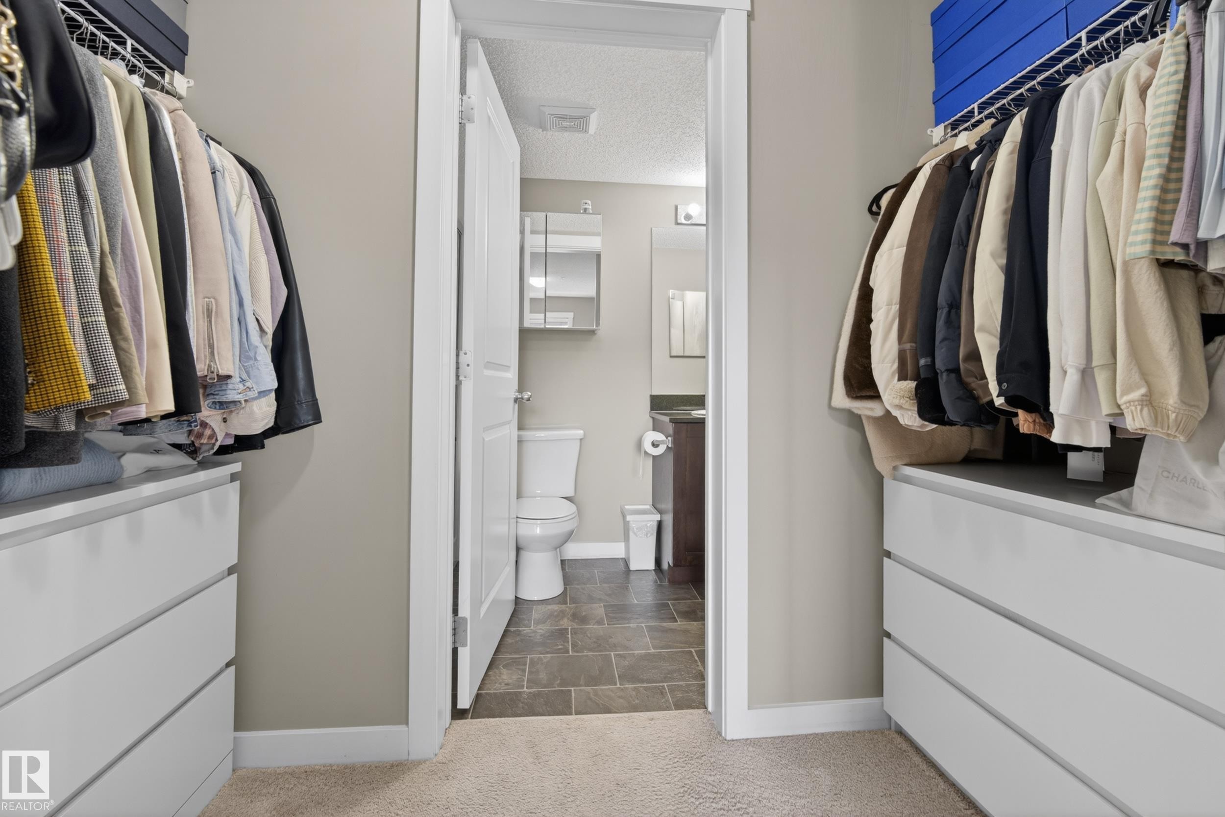 Walk-in closet with built-in white drawer units and overhead wire shelving - 314 3211 James Mowatt Trail Sw, Edmonton, AB - Indoor With Storage