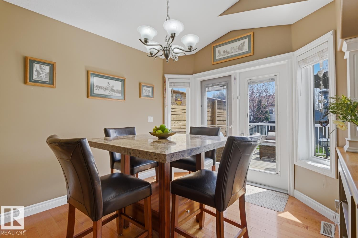 Dining area featuring bay windows, a glass-paneled door, and wood-finish flooring - 9 Danfield Place, Spruce Grove, AB - Indoor Photo Showing Dining Room