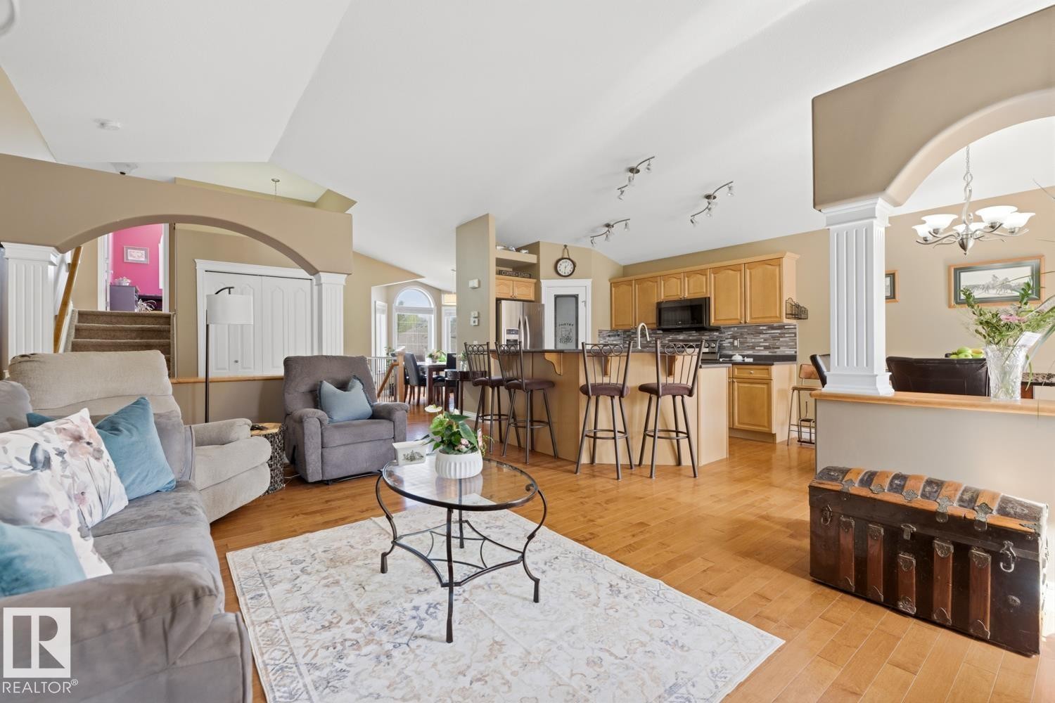 Expansive open-concept living space featuring wood-finish flooring and vaulted ceilings - 9 Danfield Place, Spruce Grove, AB - Indoor Photo Showing Living Room