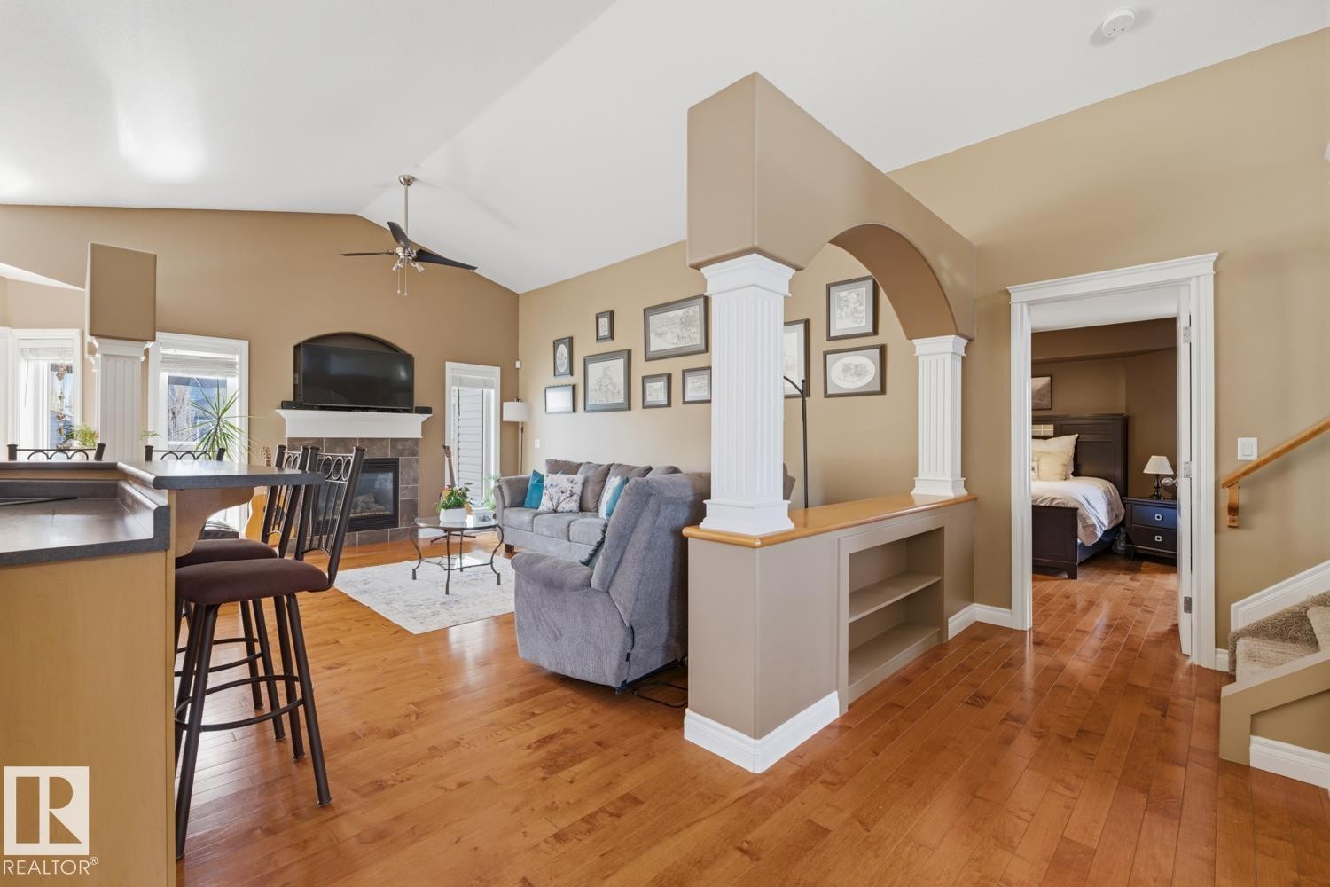 Vaulted ceilings complement the living area featuring a fireplace with a stone surround and mantel - 9 Danfield Place, Spruce Grove, AB - Indoor Photo Showing Living Room With Fireplace