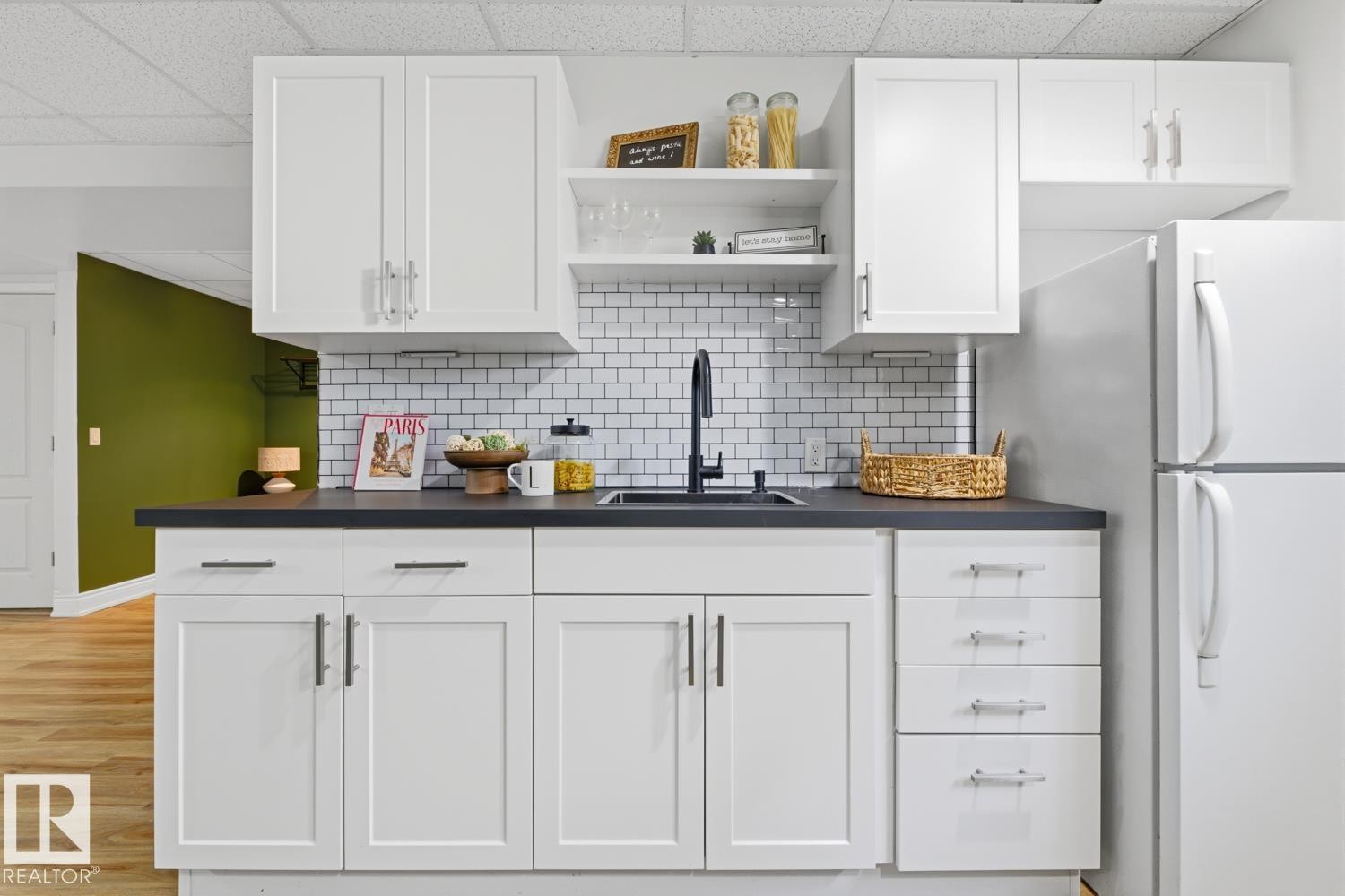 Modern kitchenette featuring white shaker cabinetry, dark countertops, a subway tile backsplash, and a black faucet - 9 Danfield Place, Spruce Grove, AB - Indoor Photo Showing Kitchen