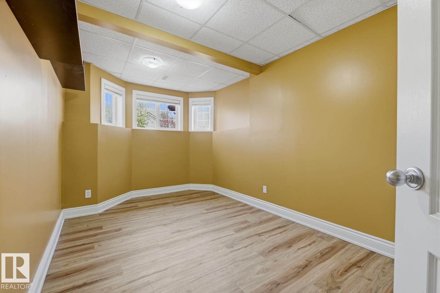 Room featuring wood-finish flooring, white baseboards, and a decorative bay window - 9 Danfield Place, Spruce Grove, AB - Indoor Photo Showing Other Room