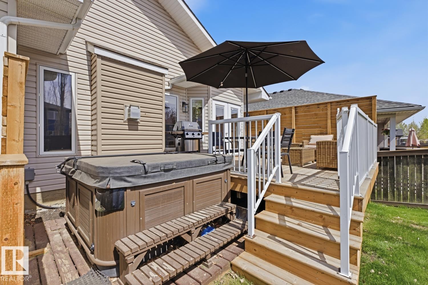 Multi-level wooden deck featuring a built-in spa with integrated steps, white railing system, and privacy screen - 9 Danfield Place, Spruce Grove, AB - Outdoor With Deck Patio Veranda With Exterior