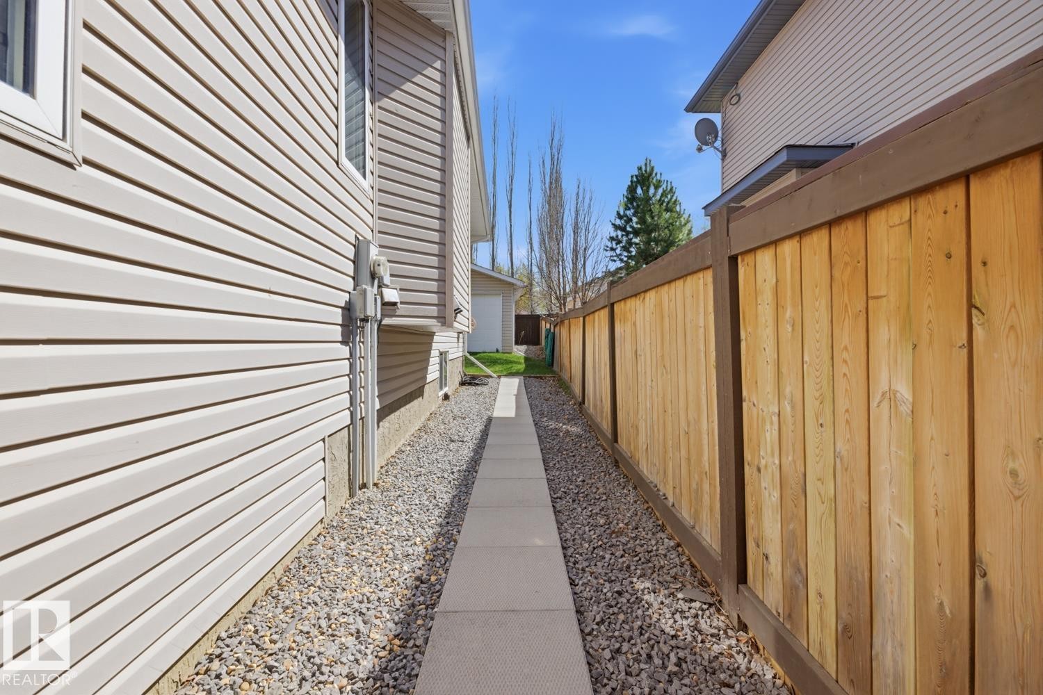 Side yard with a paved walkway, gravel bed, and horizontal vinyl siding - 9 Danfield Place, Spruce Grove, AB - Outdoor