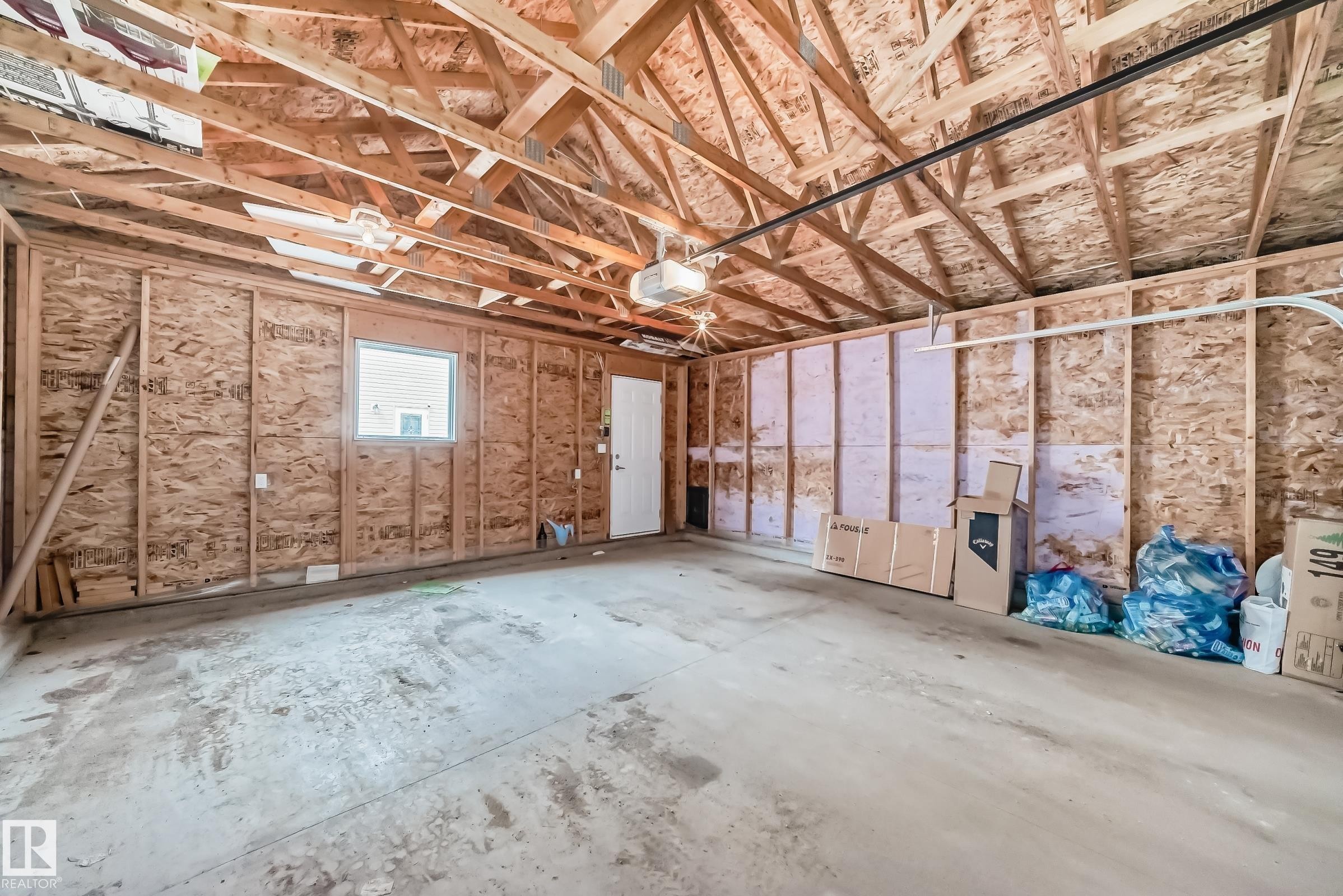 Spacious garage featuring exposed wooden rafter ceiling, concrete flooring - 6919 Cardinal Wynd, Edmonton, AB - Indoor Photo Showing Garage
