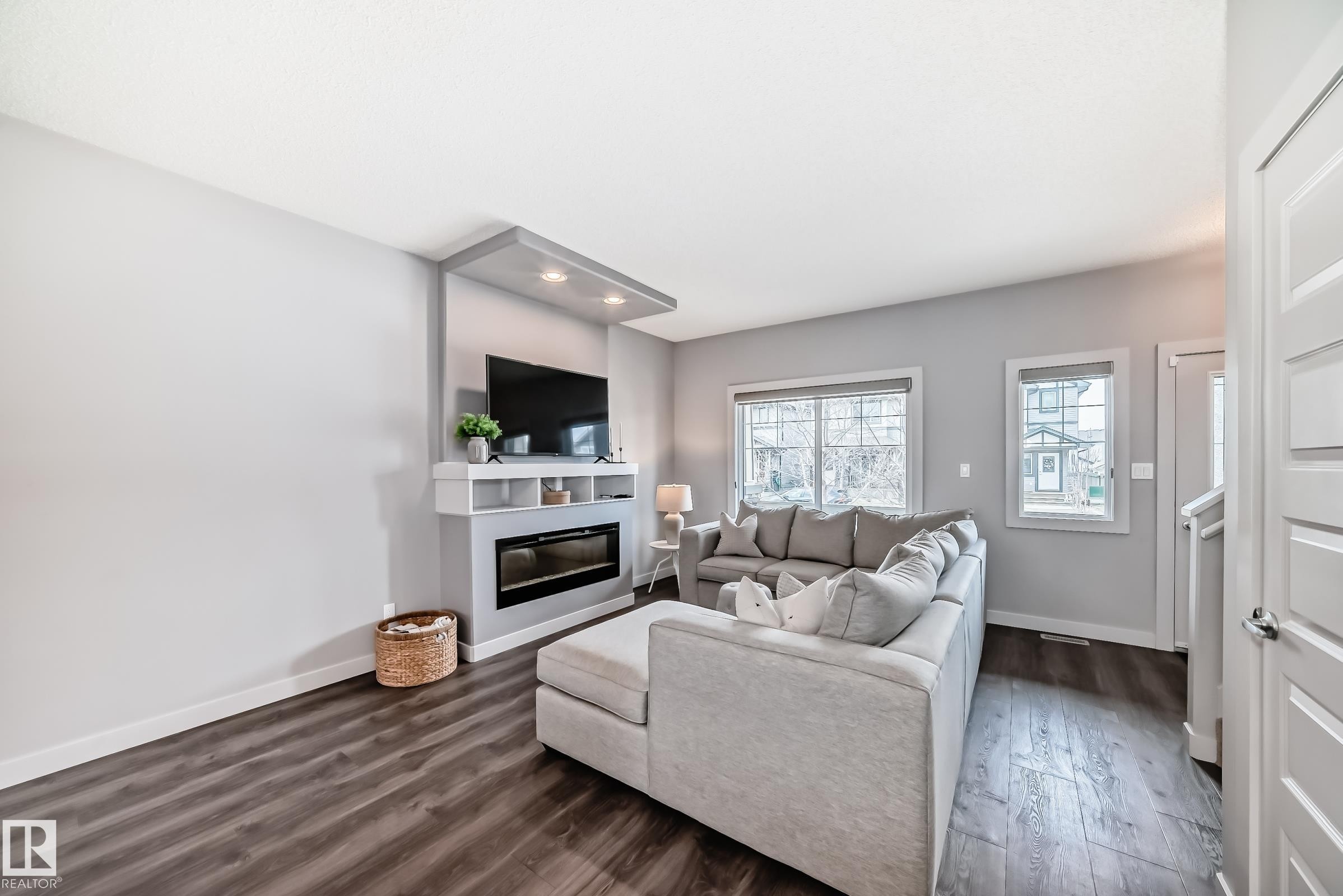 Living area featuring a built-in electric fireplace and media center with integrated lighting - 6919 Cardinal Wynd, Edmonton, AB - Indoor Photo Showing Living Room With Fireplace