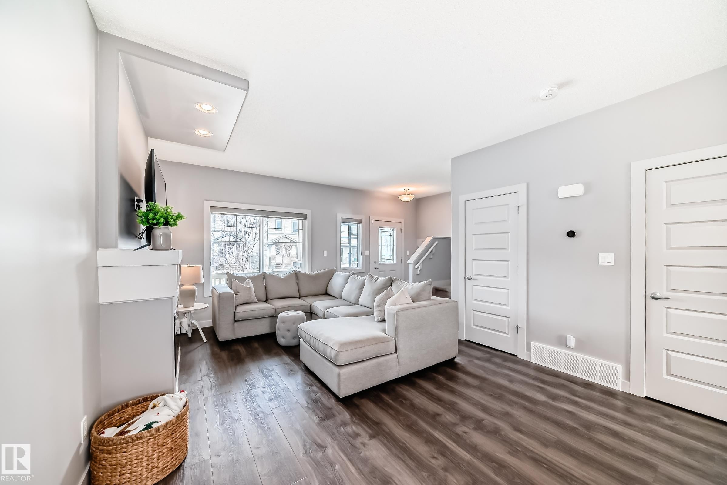 Spacious living area featuring wood-finish flooring, recessed lighting, and a window with natural light - 6919 Cardinal Wynd, Edmonton, AB - Indoor Photo Showing Living Room