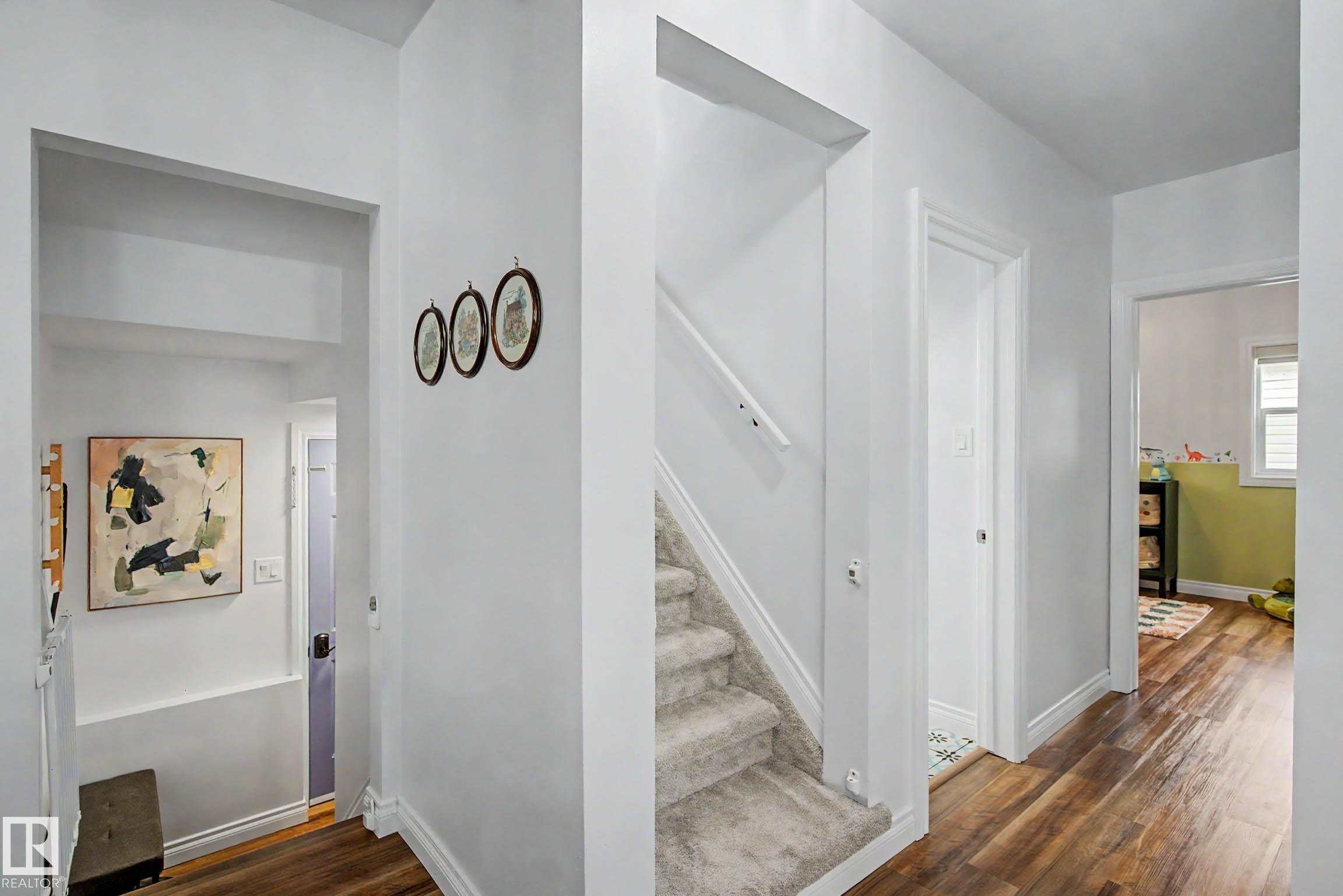 Bright hallway with wood-finish flooring extending into various rooms - 13316 109A Avenue, Edmonton, AB - Indoor Photo Showing Other Room
