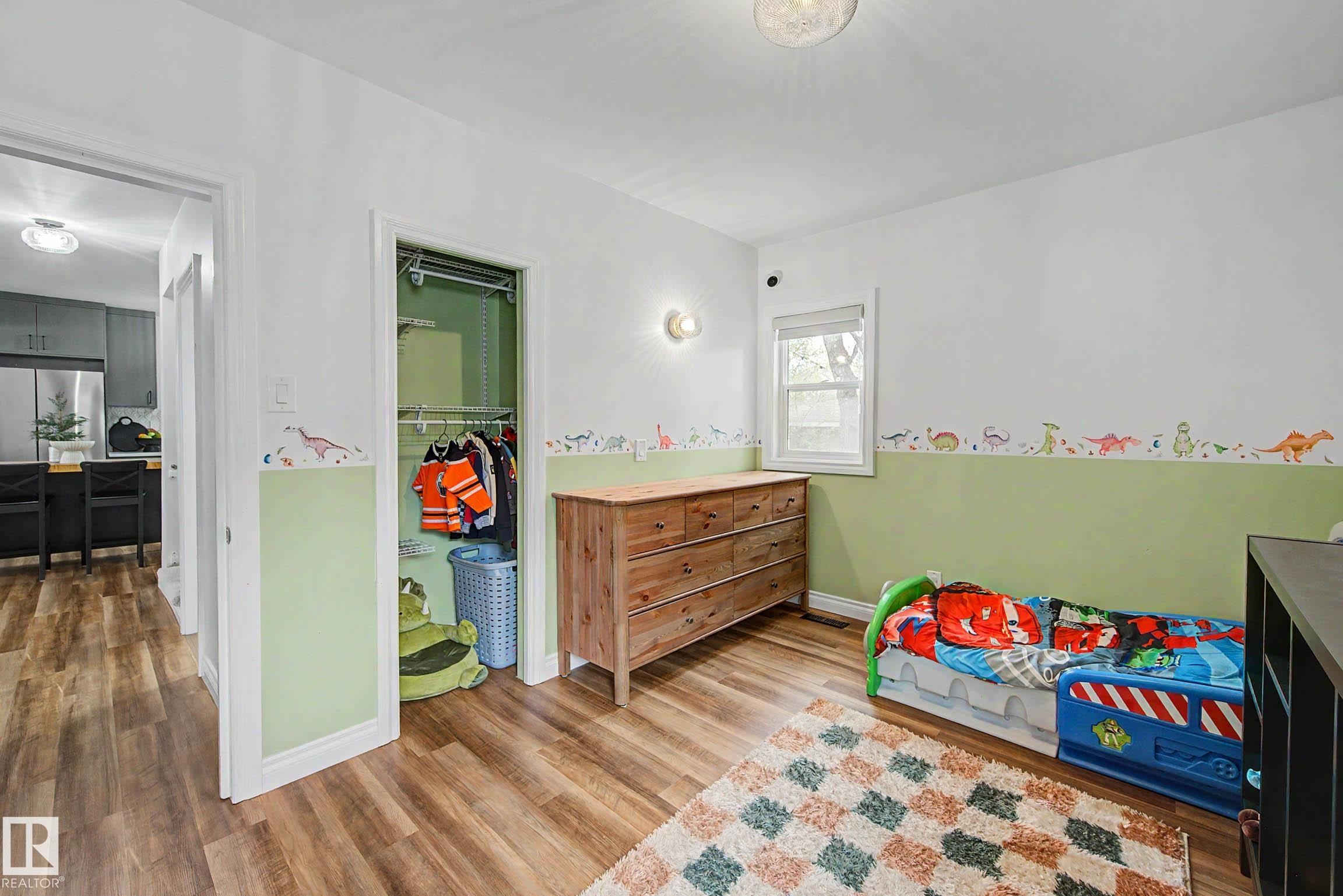 Room with wood-finish flooring, a single window, and a built-in closet with shelving and hanging rods - 13316 109A Avenue, Edmonton, AB - Indoor Photo Showing Bedroom