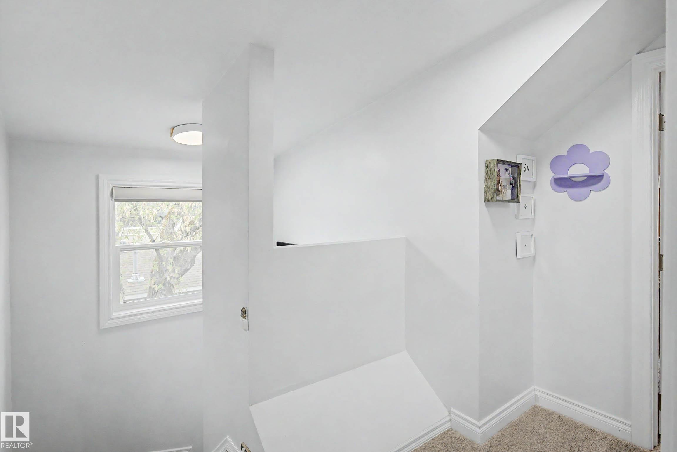 Upper-level hallway with neutral carpeting, white trim, and a white interior door - 13316 109A Avenue, Edmonton, AB - Indoor Photo Showing Other Room