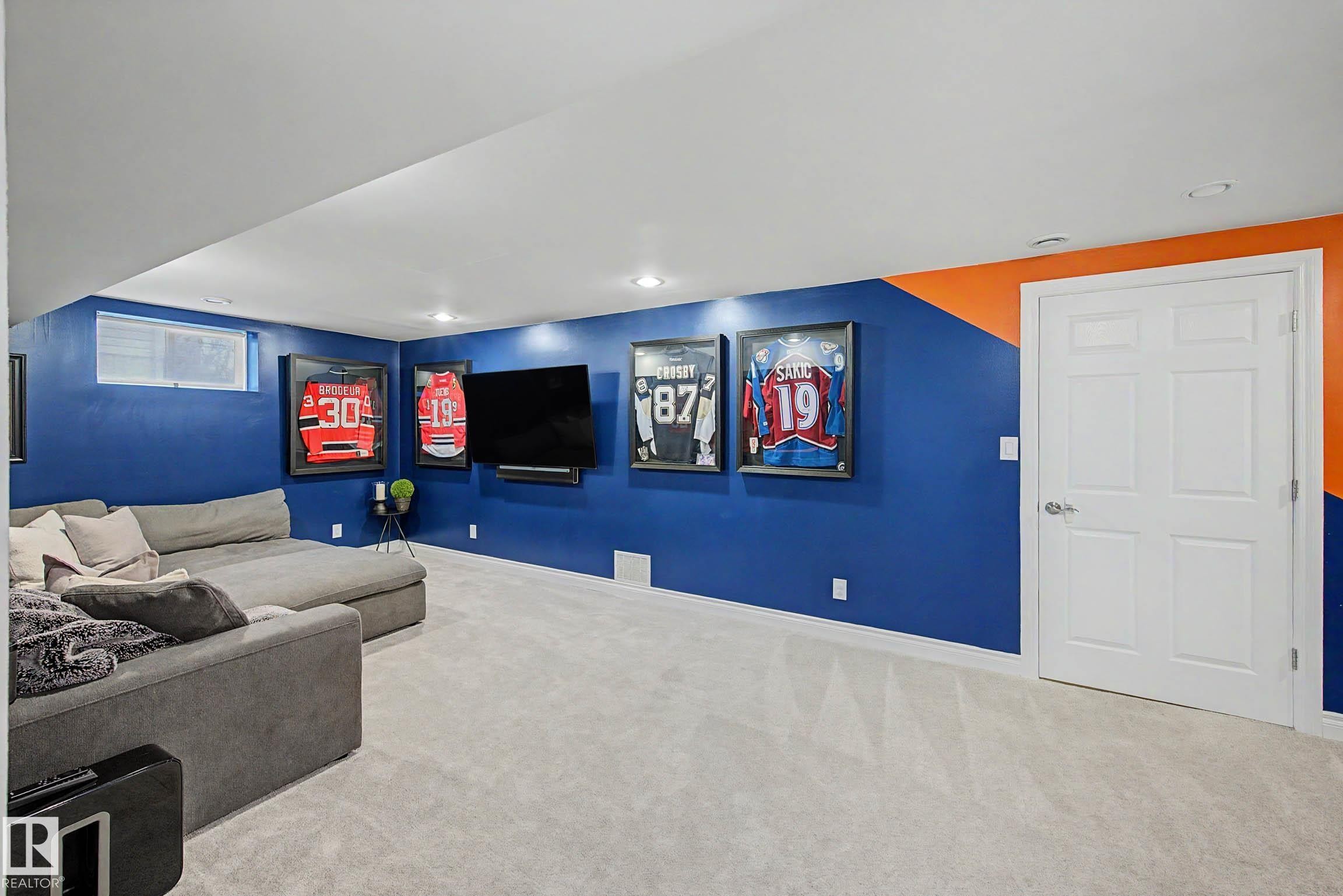 Lower level recreation space featuring plush light-toned carpeting and recessed lighting - 13316 109A Avenue, Edmonton, AB - Indoor