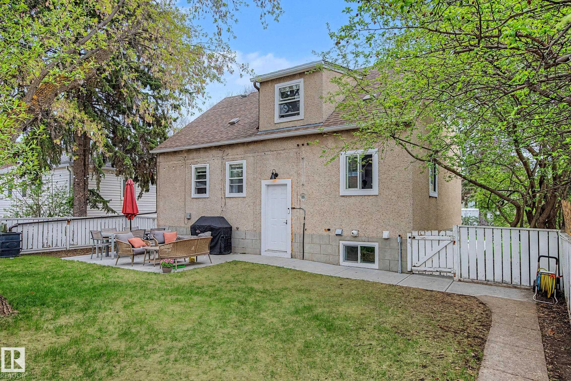 Expansive backyard featuring a manicured lawn, a concrete patio, and a privacy fence - 13316 109A Avenue, Edmonton, AB - Outdoor With Exterior