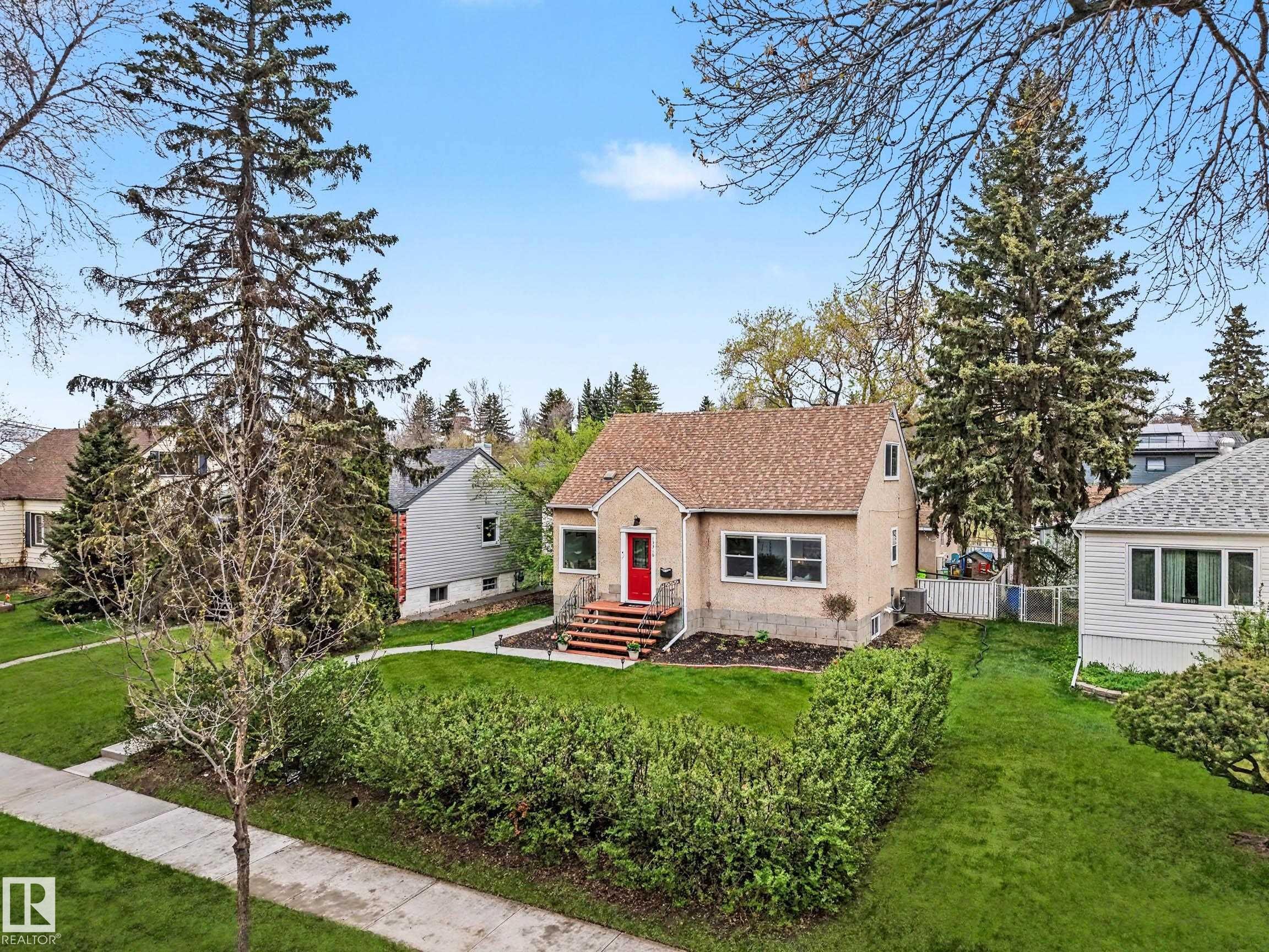 Gable-roof property featuring a textured exterior and a prominent red entry door - 13316 109A Avenue, Edmonton, AB - Outdoor