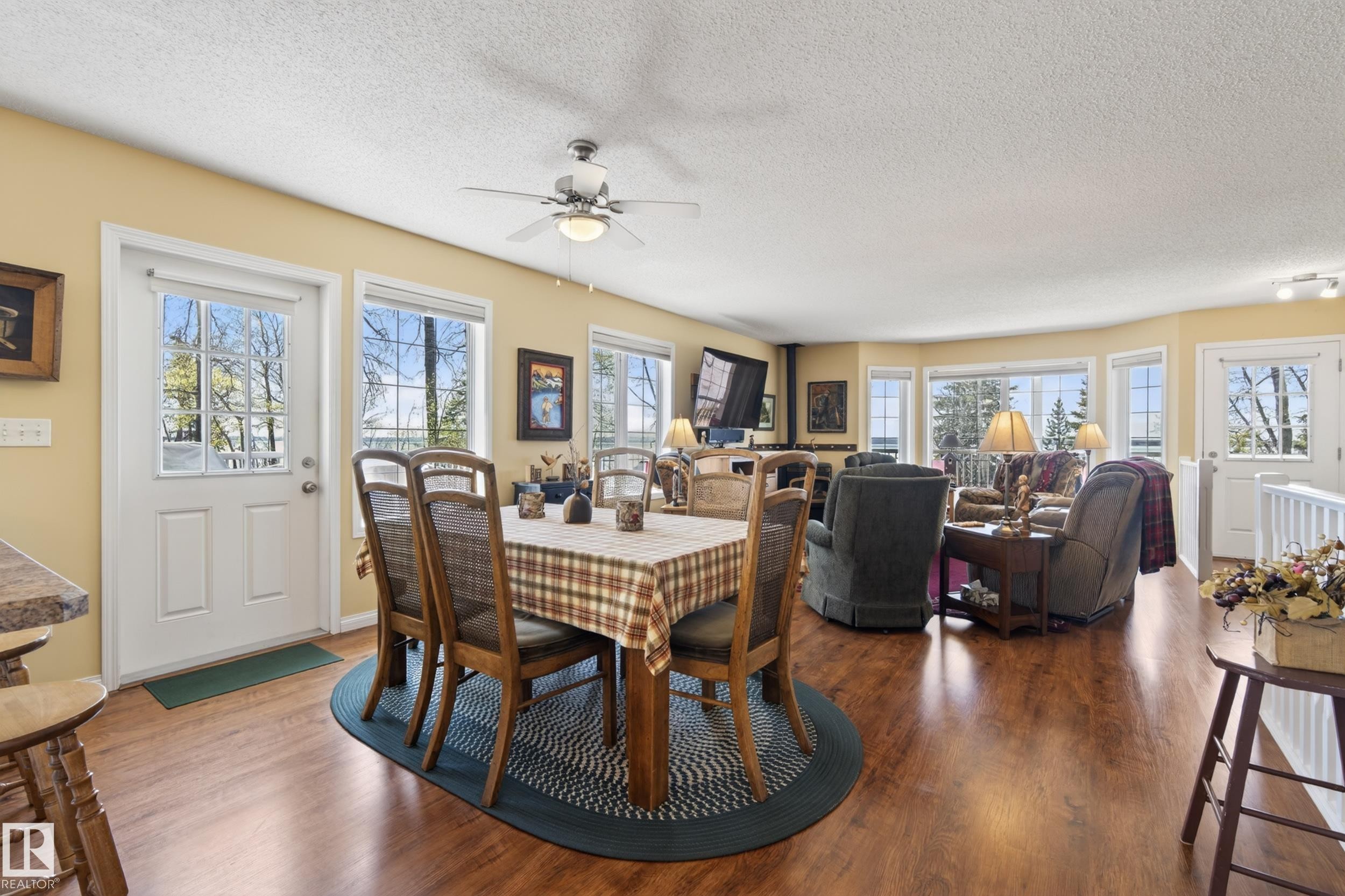 Open-concept living area featuring wood-finish flooring, a ceiling fan, and multiple windows - 77 Lakeshore Drive, Rural Leduc County, AB - Indoor Photo Showing Dining Room