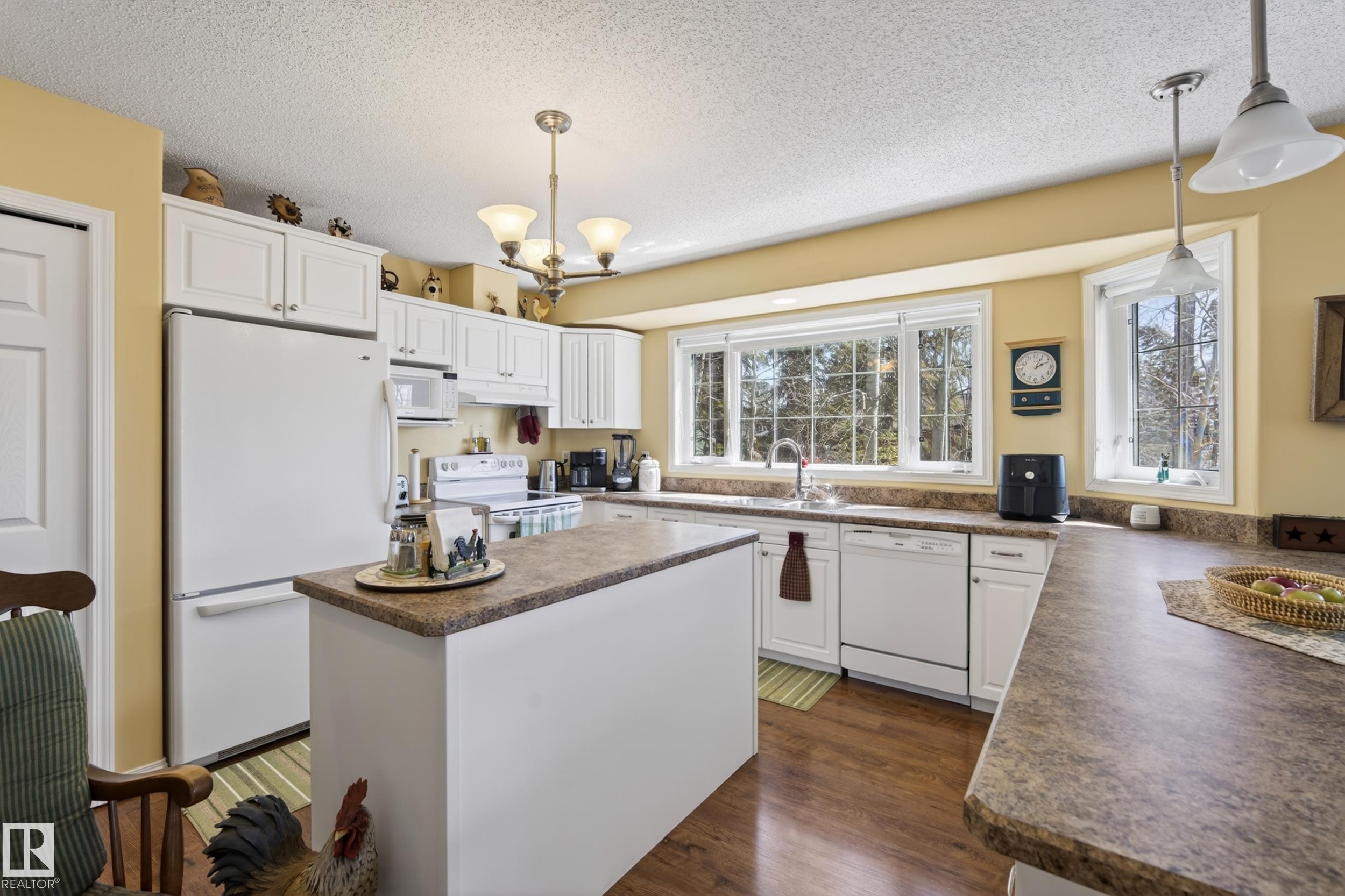 Well-appointed kitchen featuring white cabinetry and light-toned countertops - 77 Lakeshore Drive, Rural Leduc County, AB - Indoor Photo Showing Kitchen
