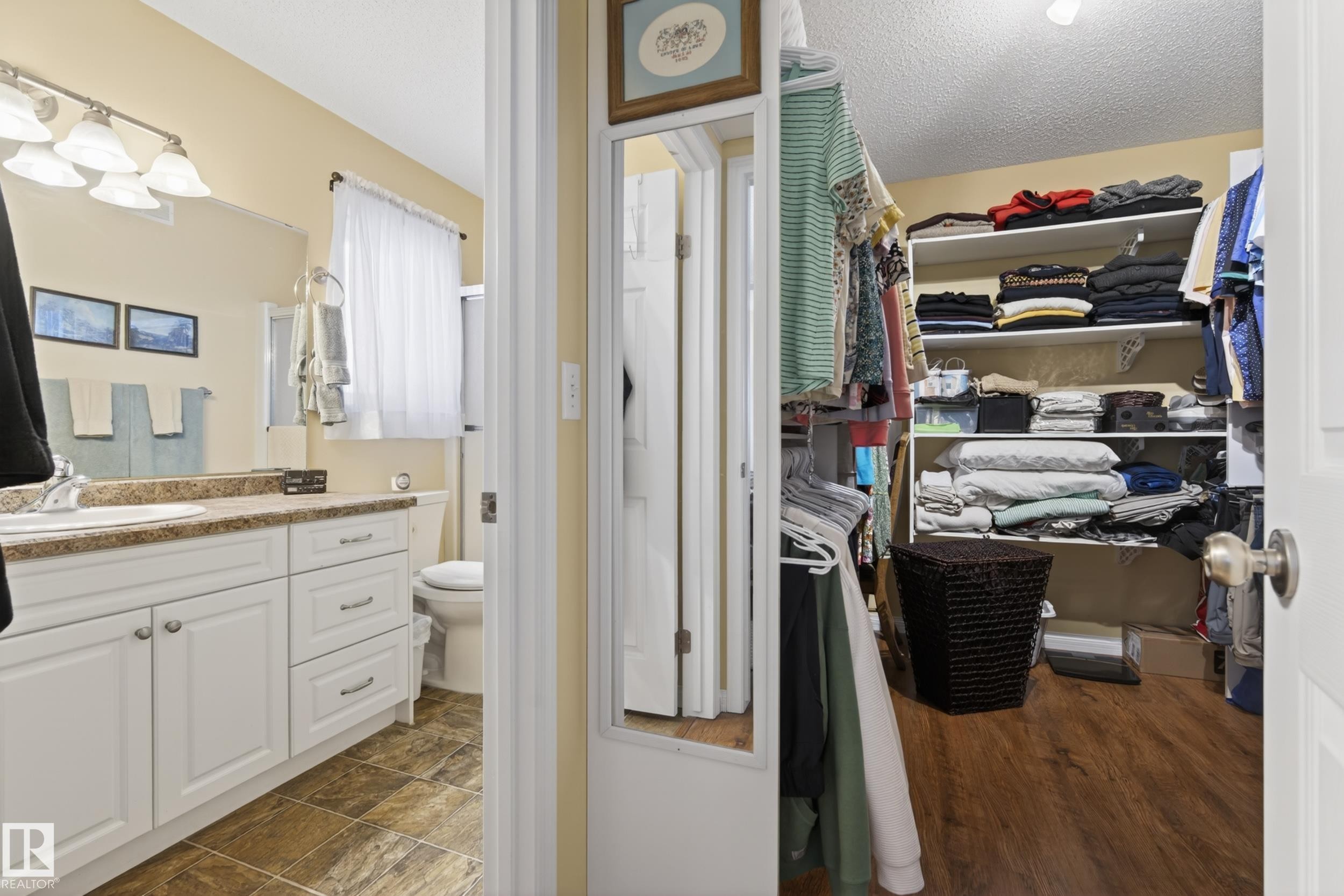 Bathroom featuring a white vanity with a brown speckled countertop, under-mount sink, and chrome fixtures - 77 Lakeshore Drive, Rural Leduc County, AB - Indoor Photo Showing Bathroom