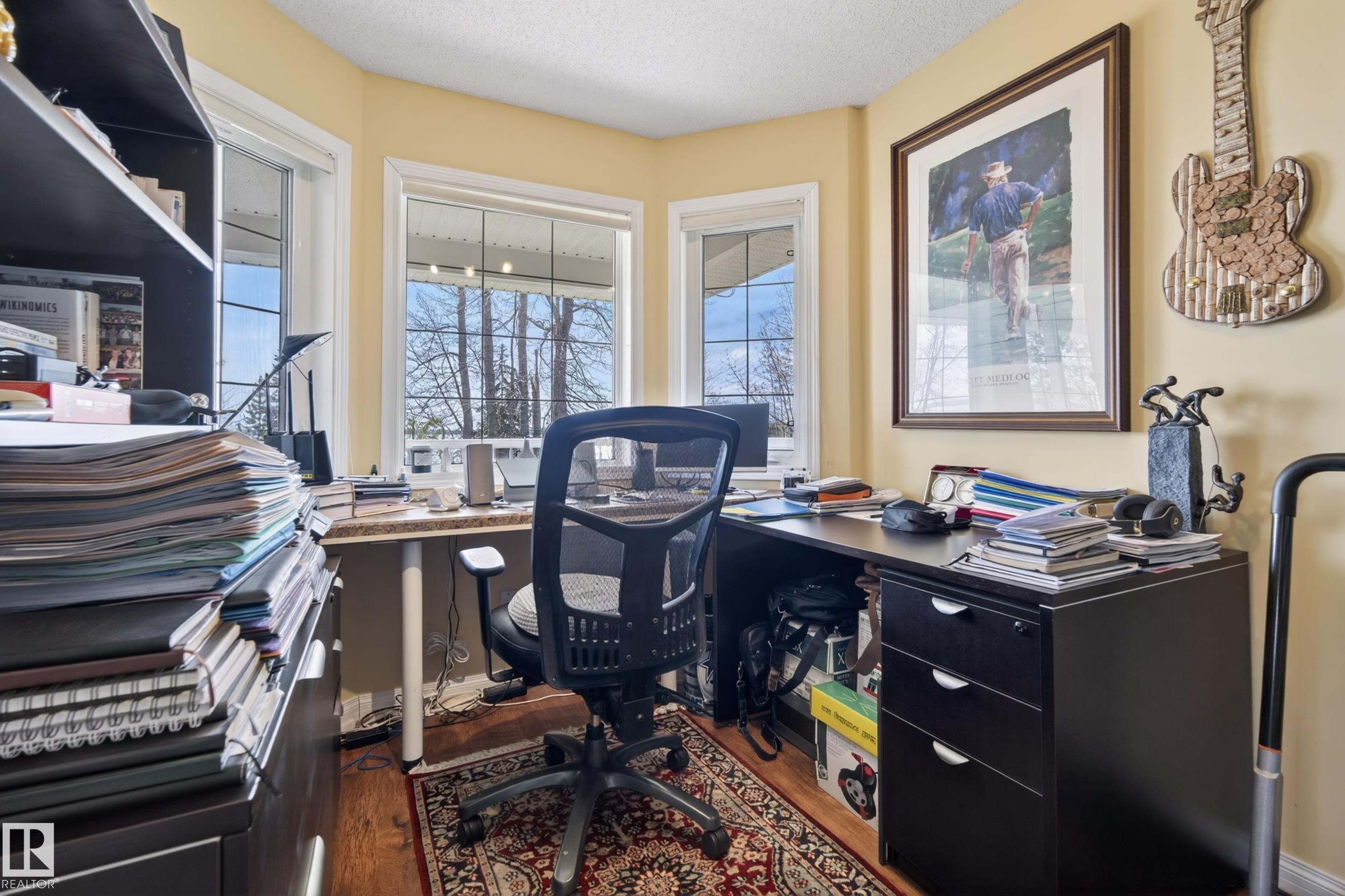 Office space featuring two large windows, wood-finish flooring, a built-in desk, and light-toned walls - 77 Lakeshore Drive, Rural Leduc County, AB - Indoor Photo Showing Office