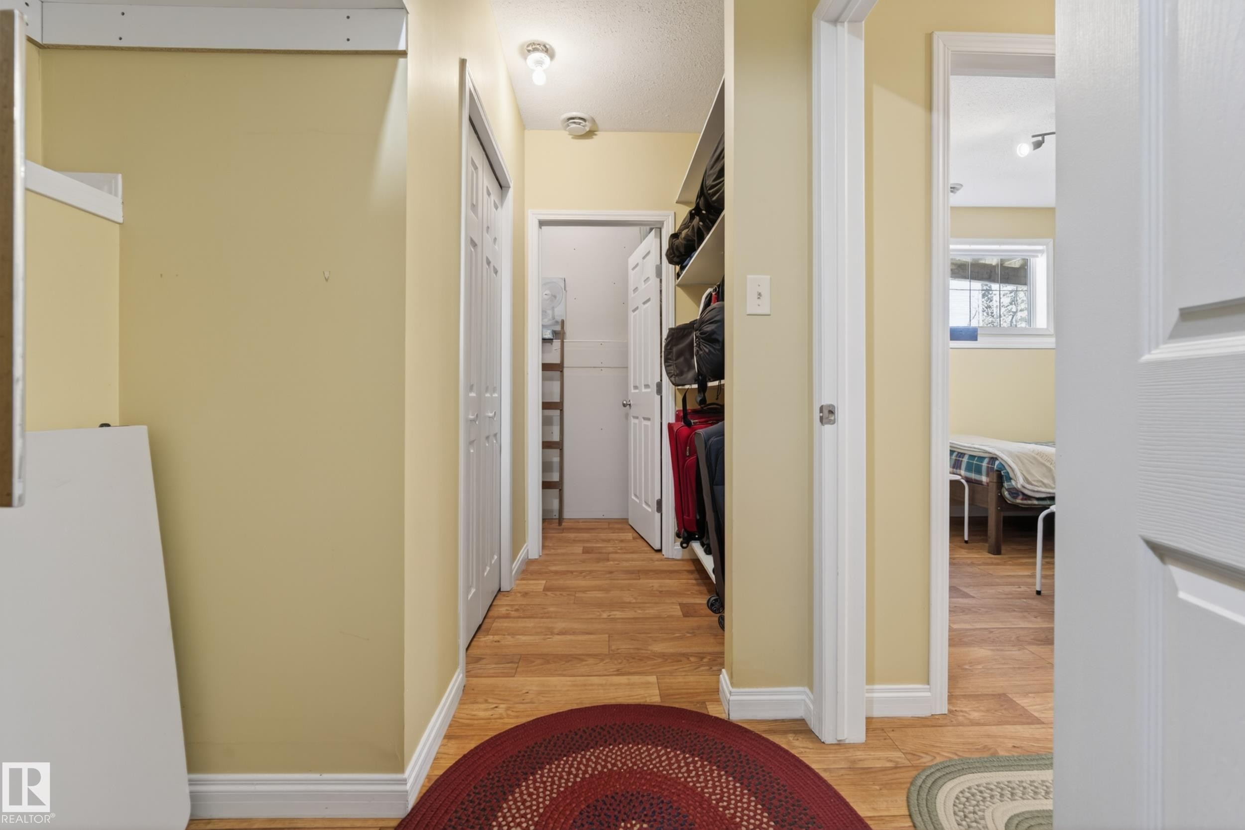 Hallway featuring wood-finish flooring, light yellow painted walls, and white trim - 77 Lakeshore Drive, Rural Leduc County, AB - Indoor Photo Showing Other Room
