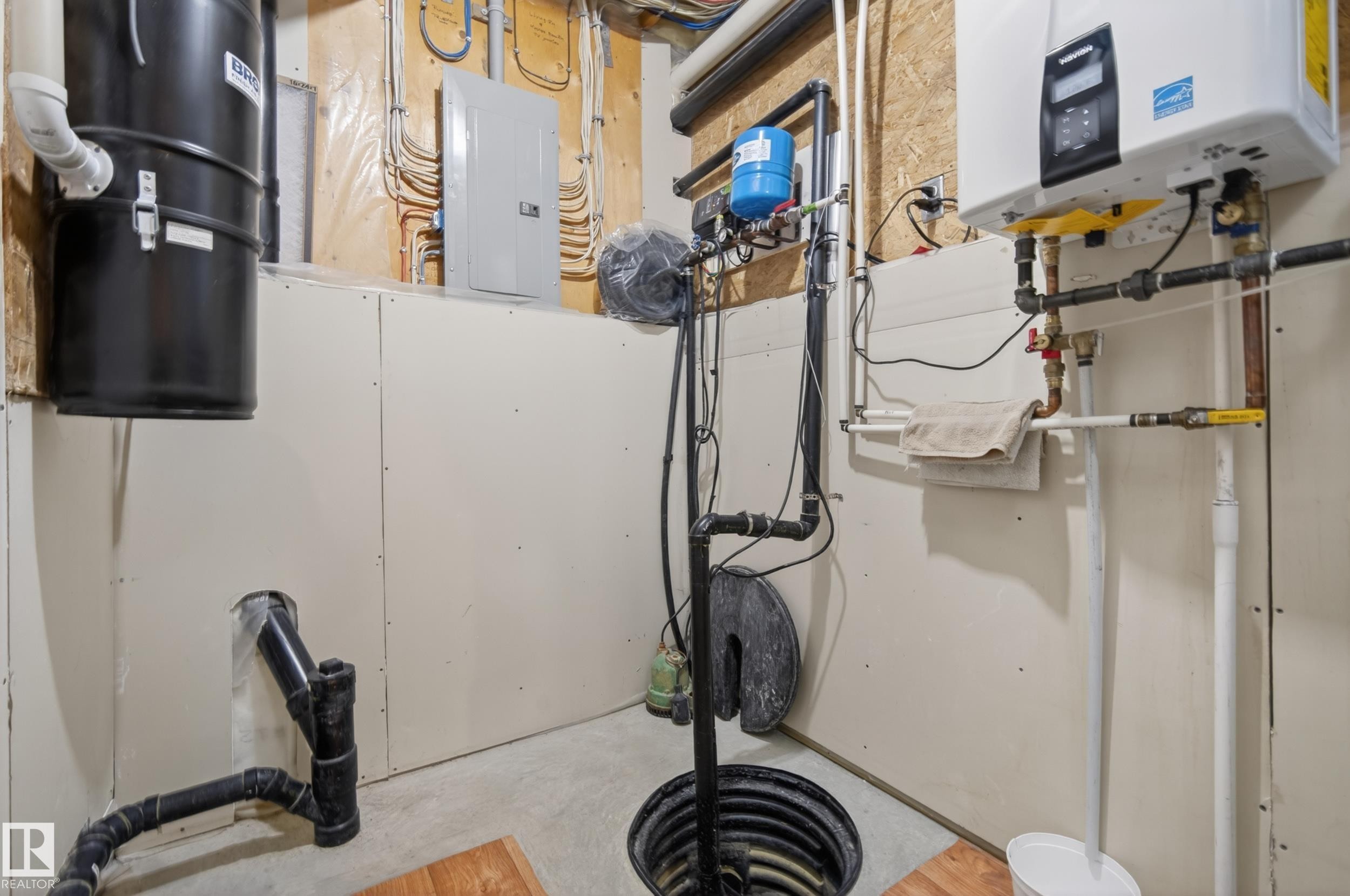 Utility area featuring a water heater, central vacuum system, sump pump, and electrical panel - 77 Lakeshore Drive, Rural Leduc County, AB - Indoor Photo Showing Basement