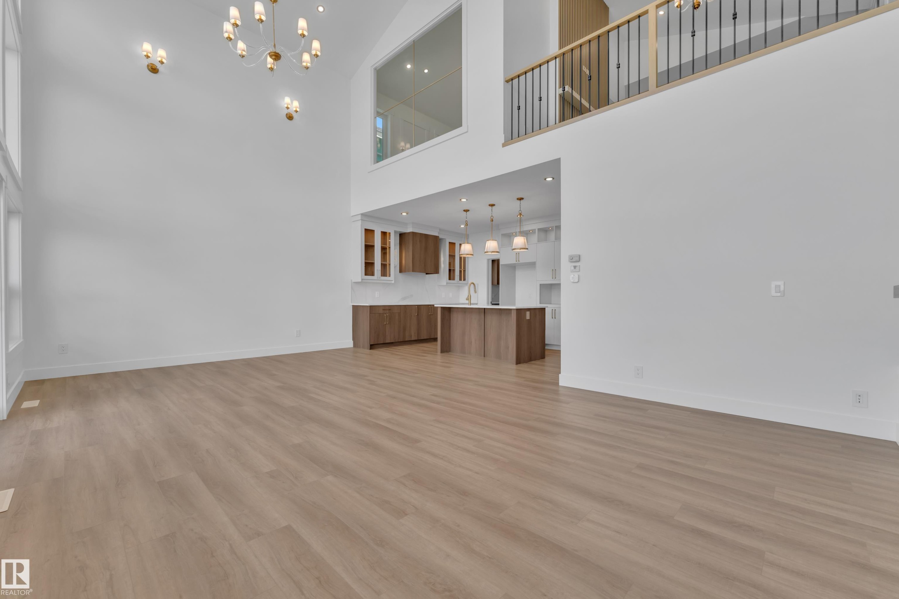 Spacious open-concept living area featuring light wood-finish flooring and high vaulted ceilings - 13128 187 Avenue, Edmonton, AB - Indoor Photo Showing Other Room