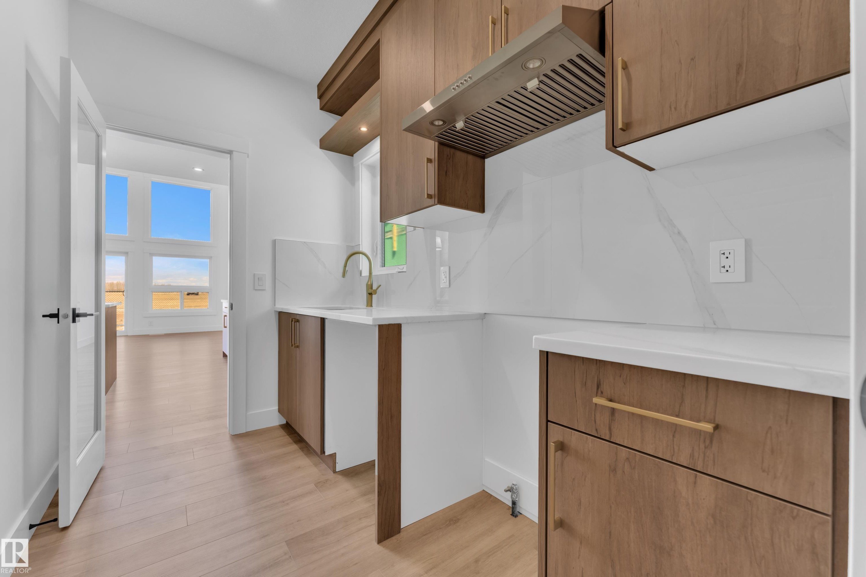 Kitchenette featuring light wood-finish cabinetry, white countertops, and a white marble-look backsplash - 13128 187 Avenue, Edmonton, AB - Indoor Photo Showing Kitchen