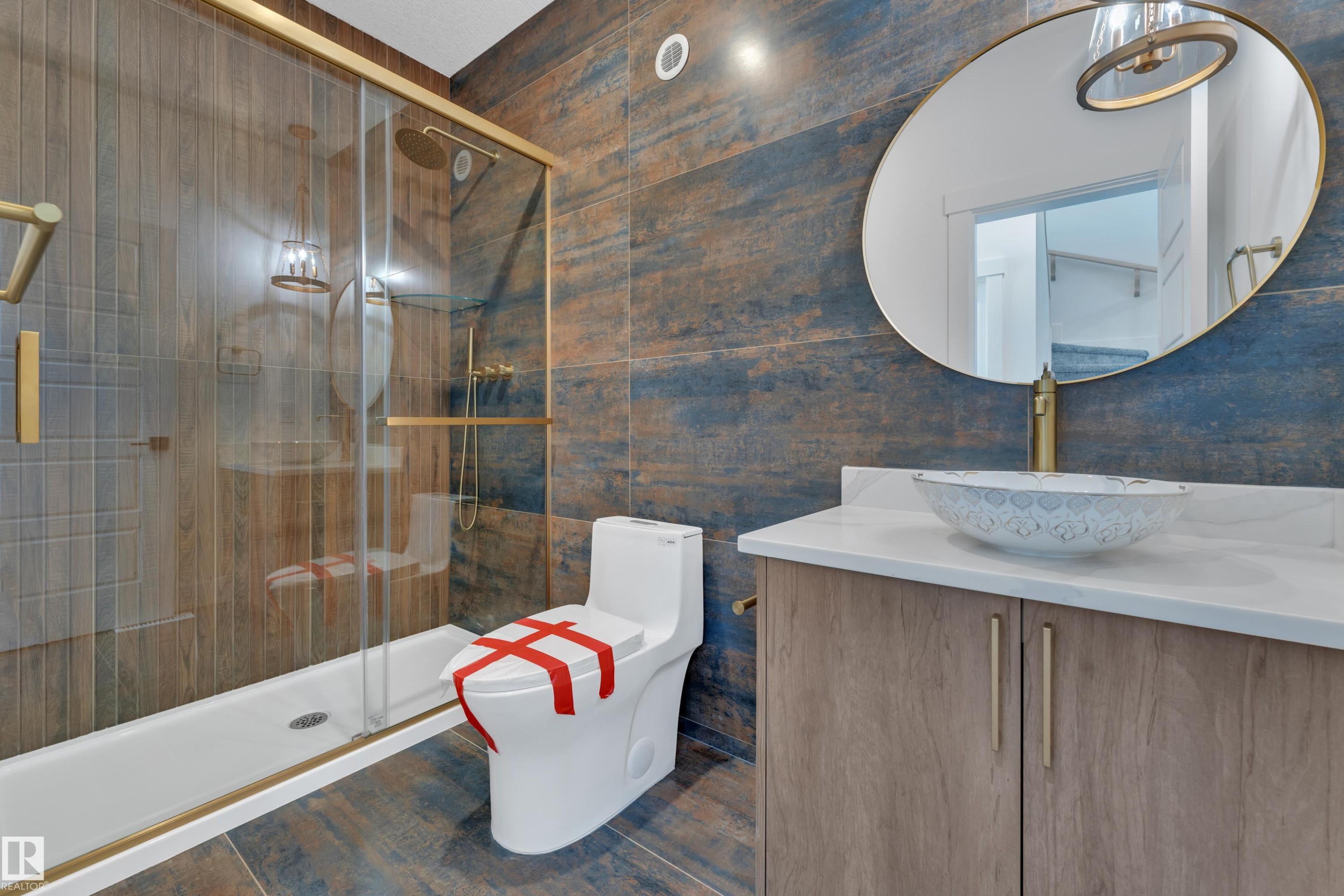 Stylish bathroom featuring a glass-enclosed shower with gold-tone hardware, a porcelain toilet, and a vanity with a vessel sink - 13128 187 Avenue, Edmonton, AB - Indoor Photo Showing Bathroom