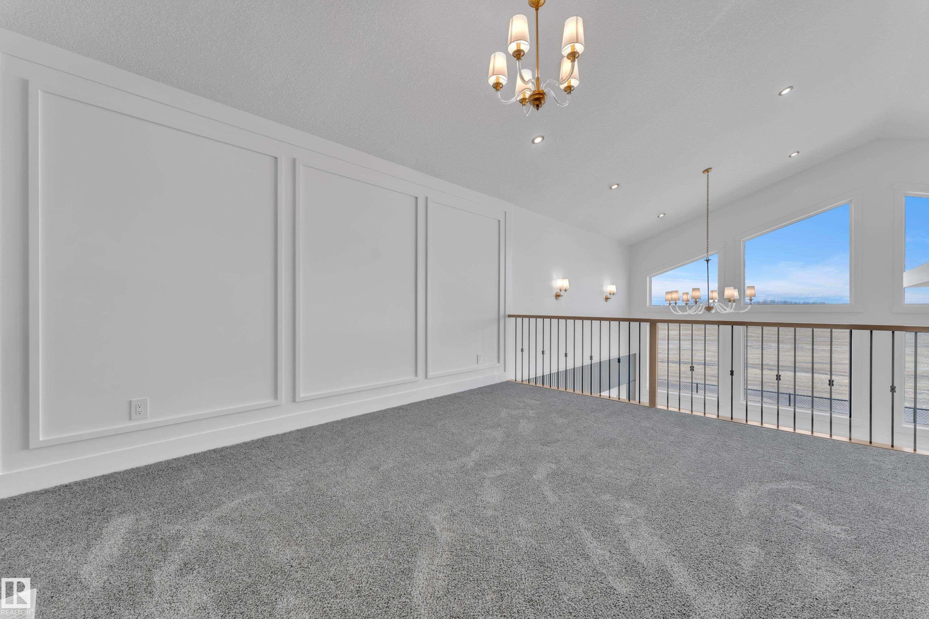 Upper-level space featuring grey carpet flooring, wall paneling, and an open railing overlooking the lower level - 13128 187 Avenue, Edmonton, AB - Indoor Photo Showing Other Room
