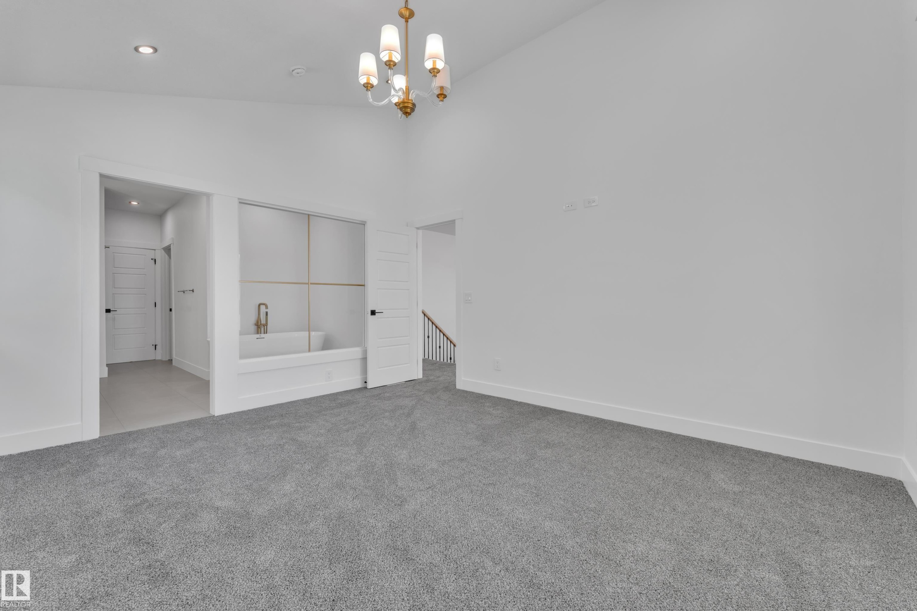 Spacious room with vaulted ceilings and a stylish gold chandelier - 13128 187 Avenue, Edmonton, AB - Indoor Photo Showing Other Room