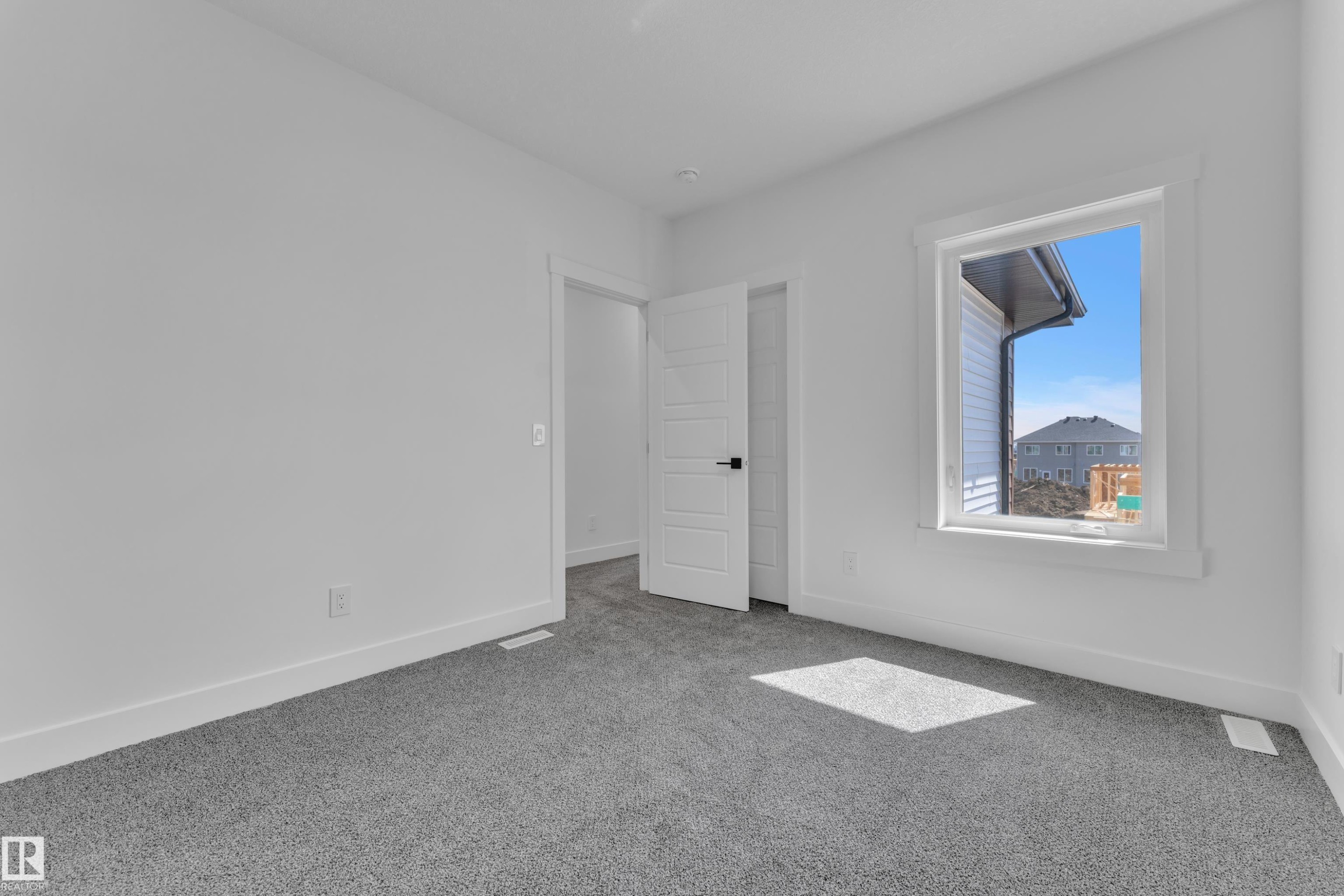 Neutral-toned carpeting and bright white walls create a versatile interior space - 13128 187 Avenue, Edmonton, AB - Indoor Photo Showing Other Room
