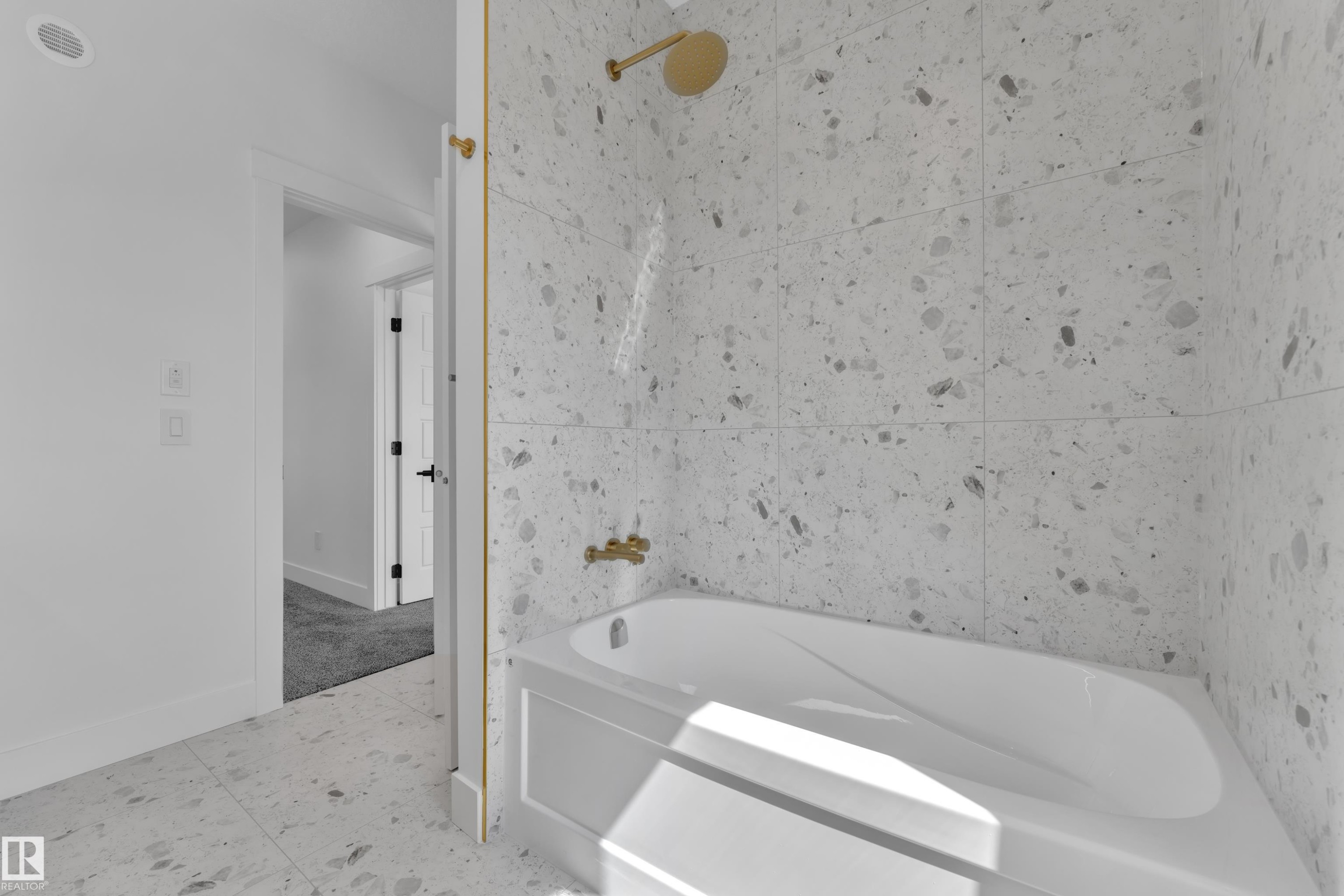 Bathtub with gold-finish shower fixtures and a tiled surround - 13128 187 Avenue, Edmonton, AB - Indoor Photo Showing Bathroom