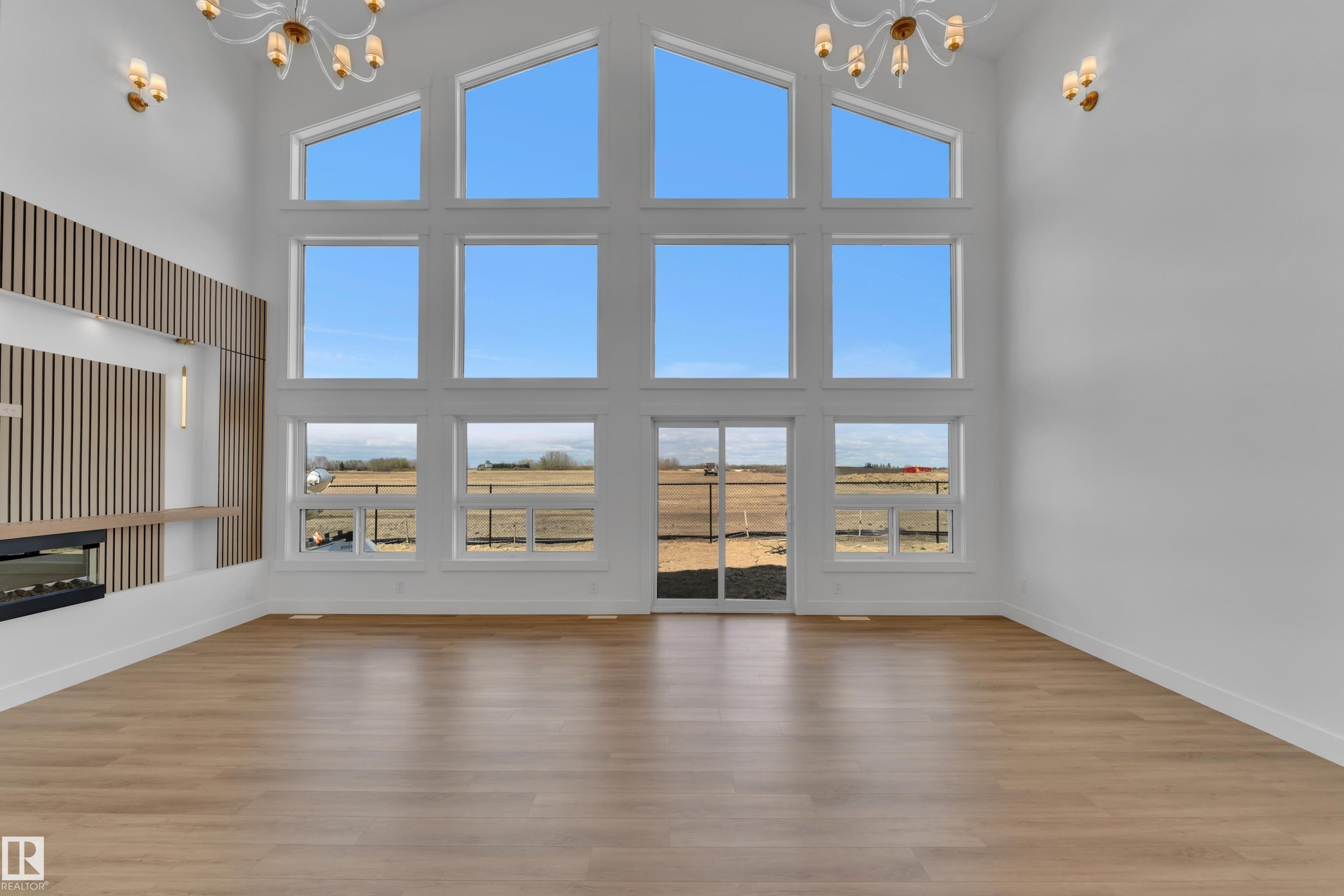 Vaulted ceilings with large-pane window array, wood-finish flooring, and a contemporary fireplace feature - 13128 187 Avenue, Edmonton, AB - Indoor